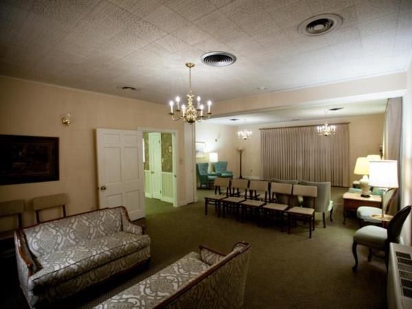 A living room with a couch and chairs and a chandelier
