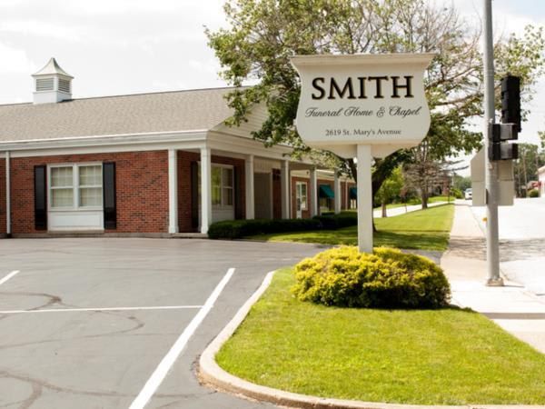 A sign for smith funeral home and chapel is in front of a brick building