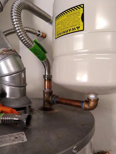 A close up of a water heater with a warning sign on it.