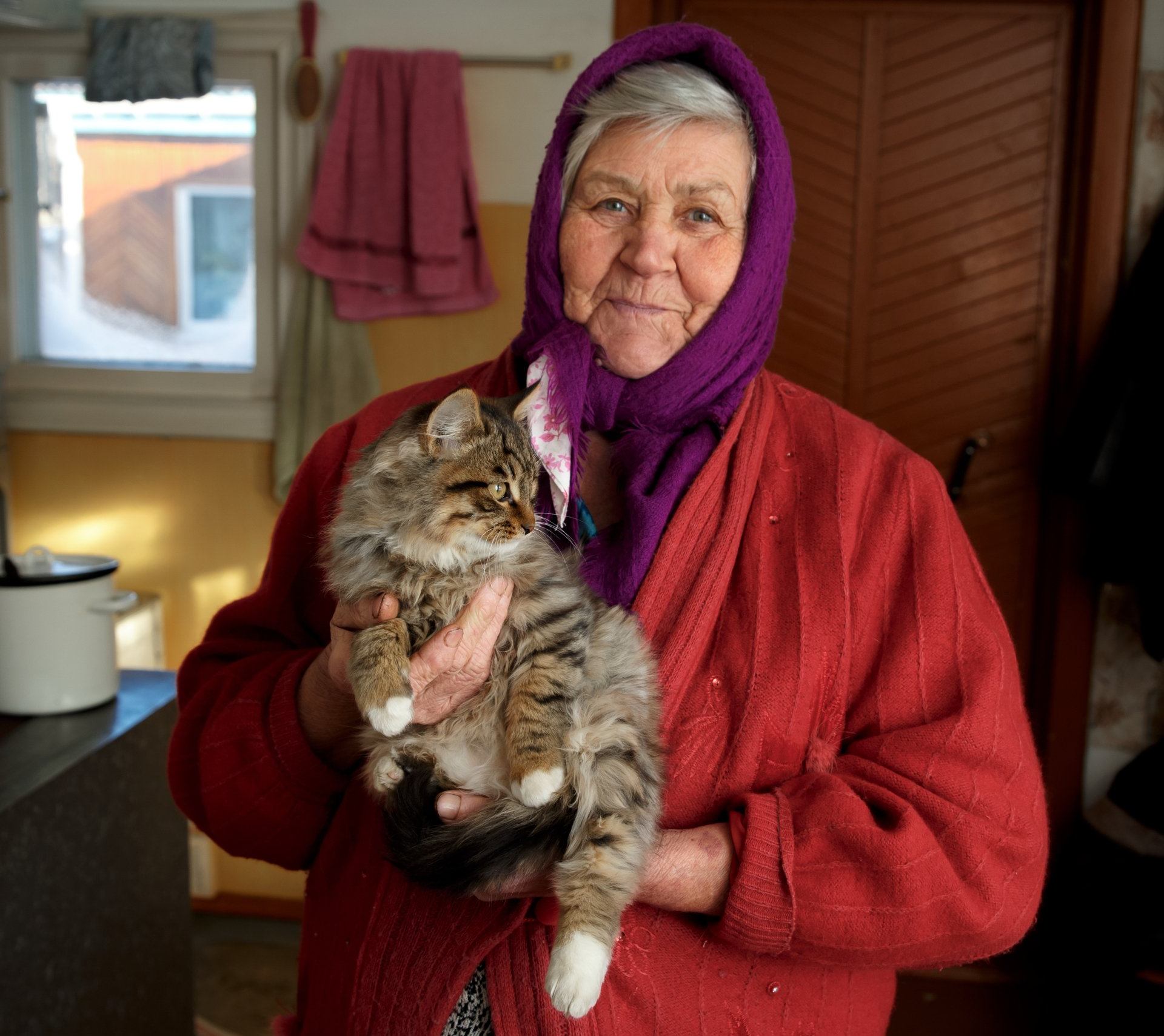 old woman holding her cat with arthritis