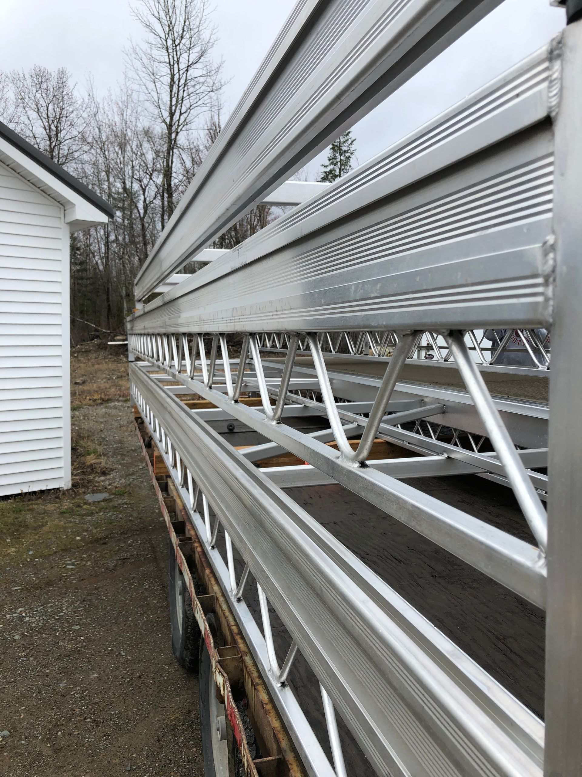 A large metal structure is sitting in front of a white house.