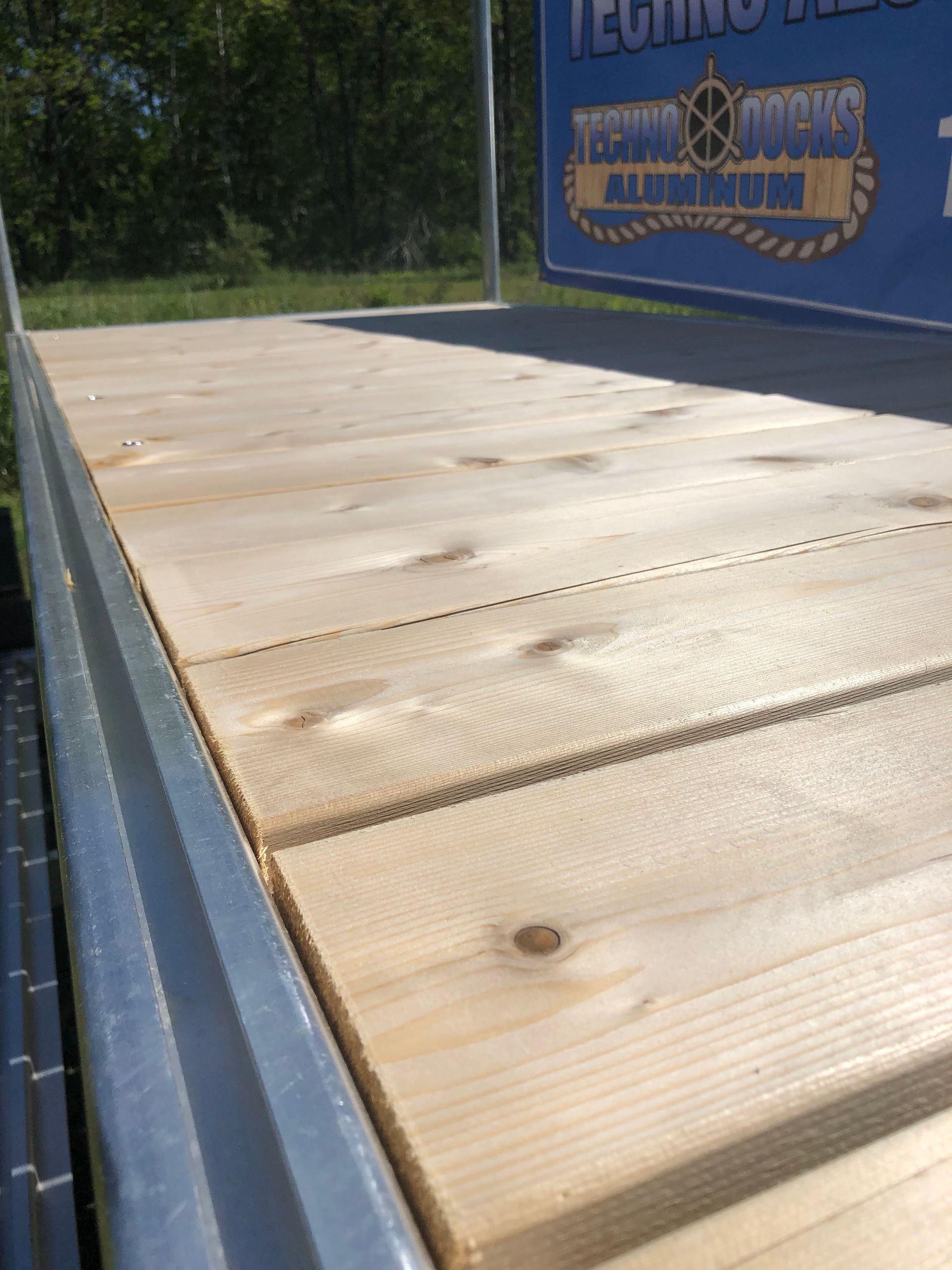 A close up of a wooden deck with a sign in the background.
