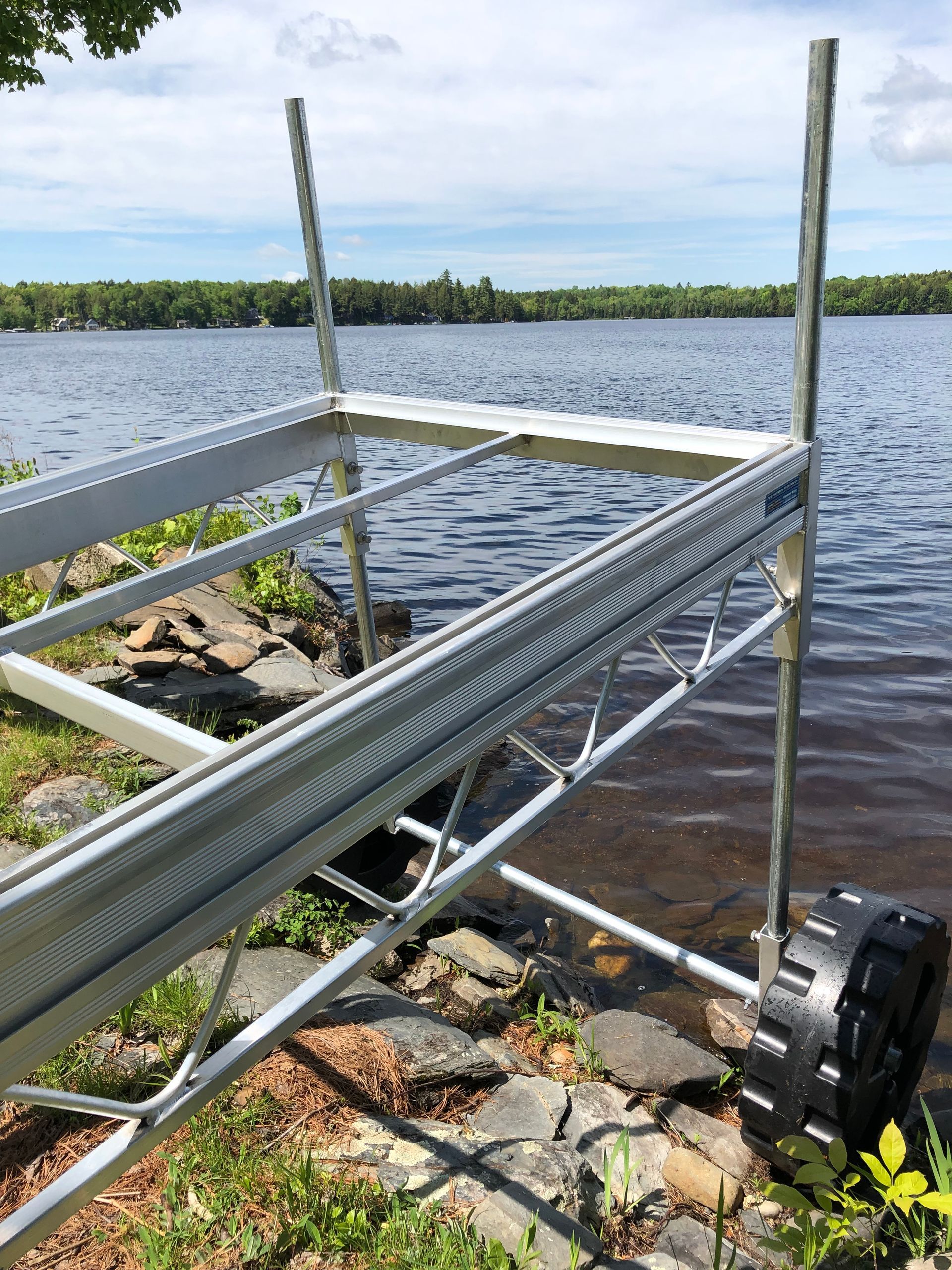 A metal dock is sitting on the shore of a lake.