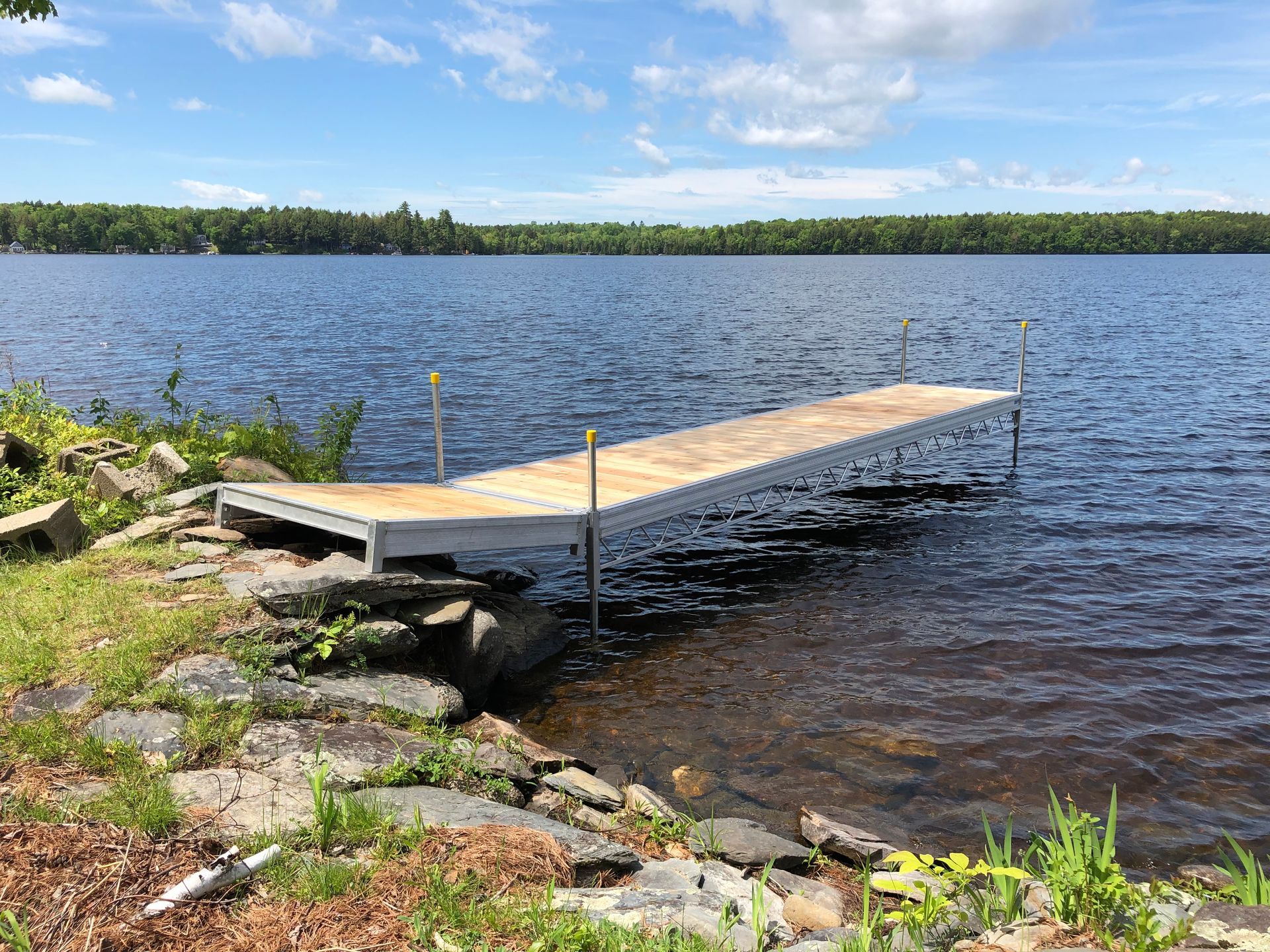A dock is sitting on the shore of a lake.