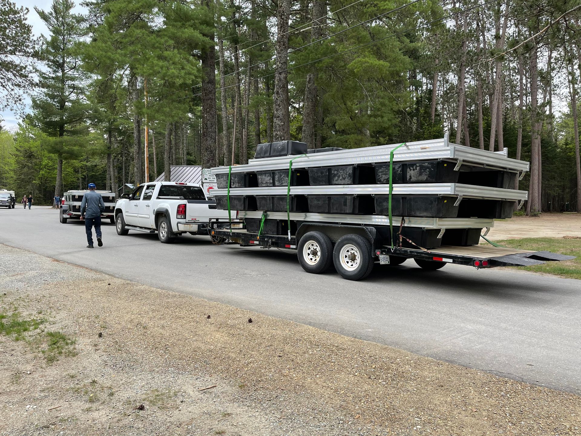 A truck is towing a trailer with a boat on it.