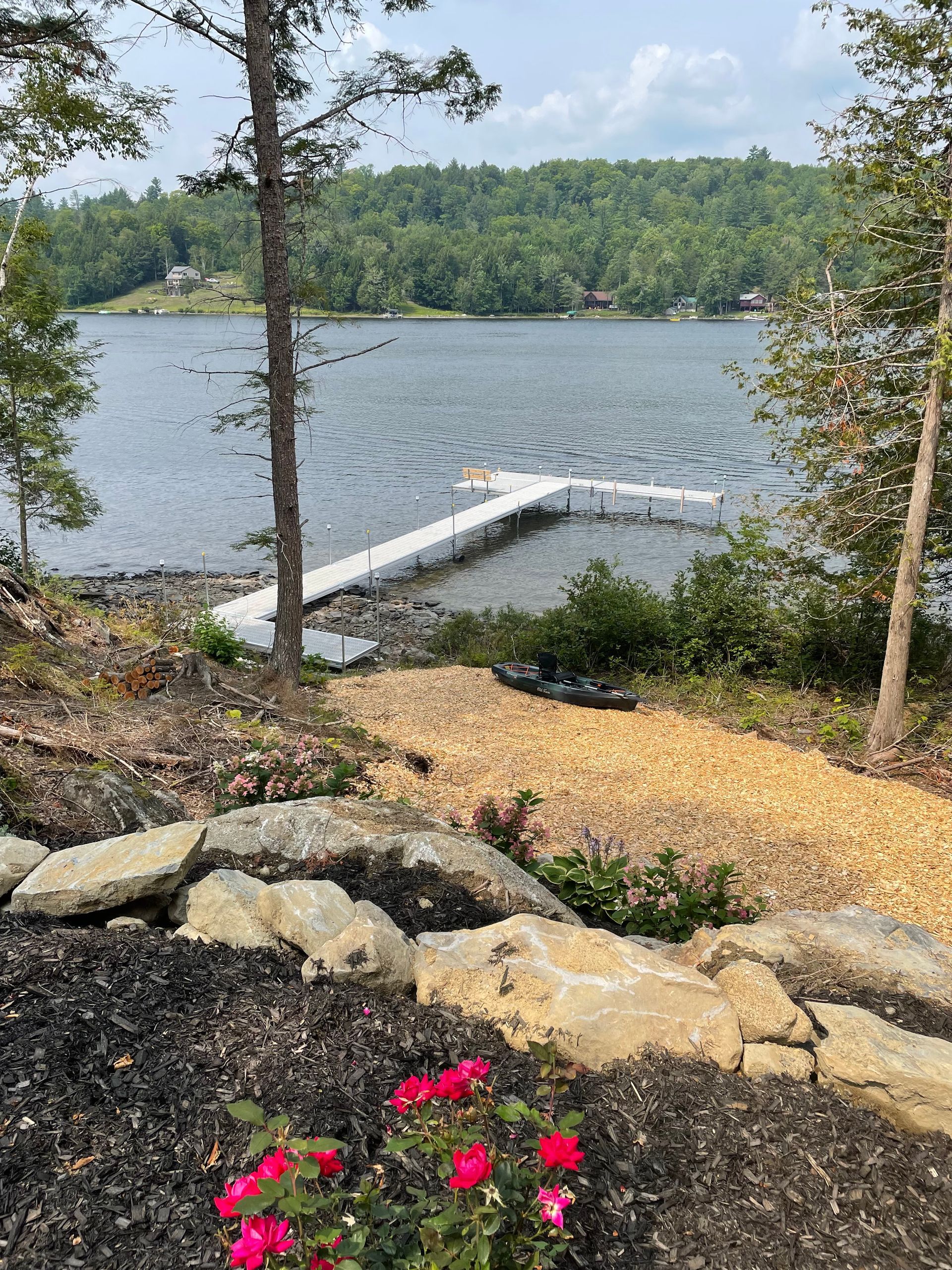 There is a dock in the middle of the lake surrounded by trees.