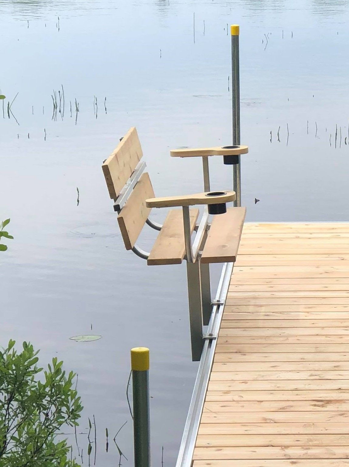 A wooden bench sits on a dock overlooking a body of water