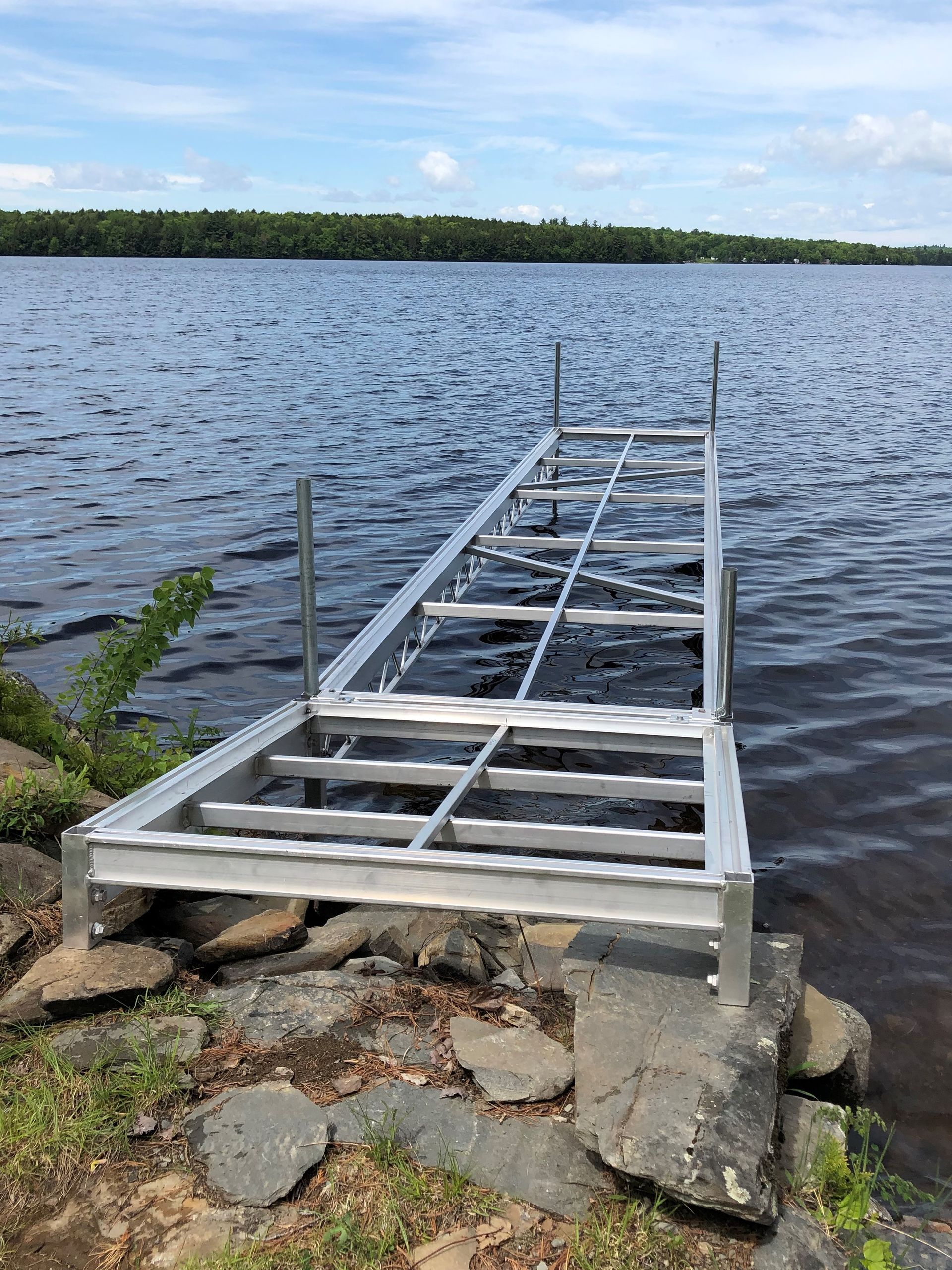 A metal dock is sitting on the shore of a lake.