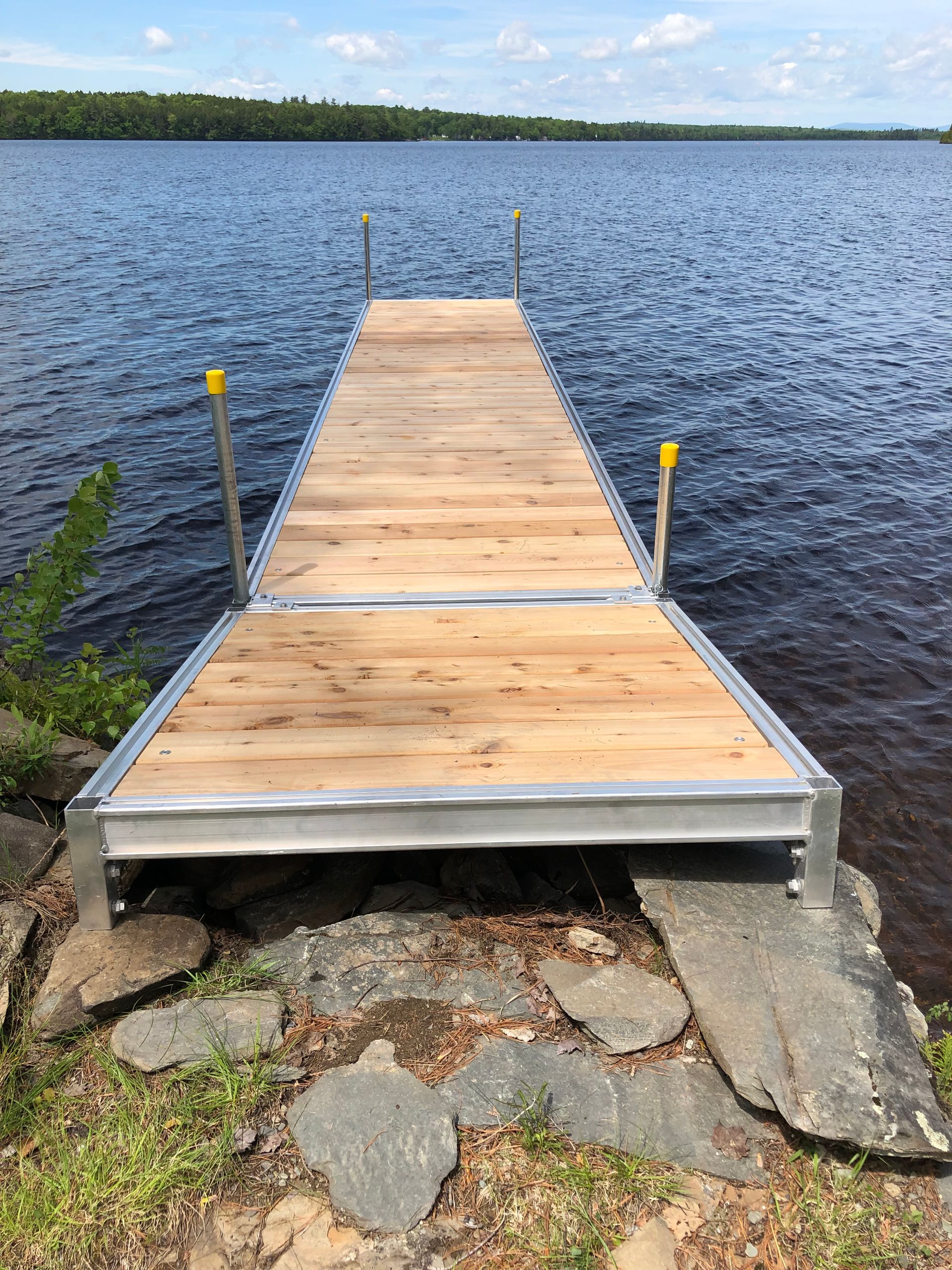 A wooden dock is sitting on the shore of a lake.