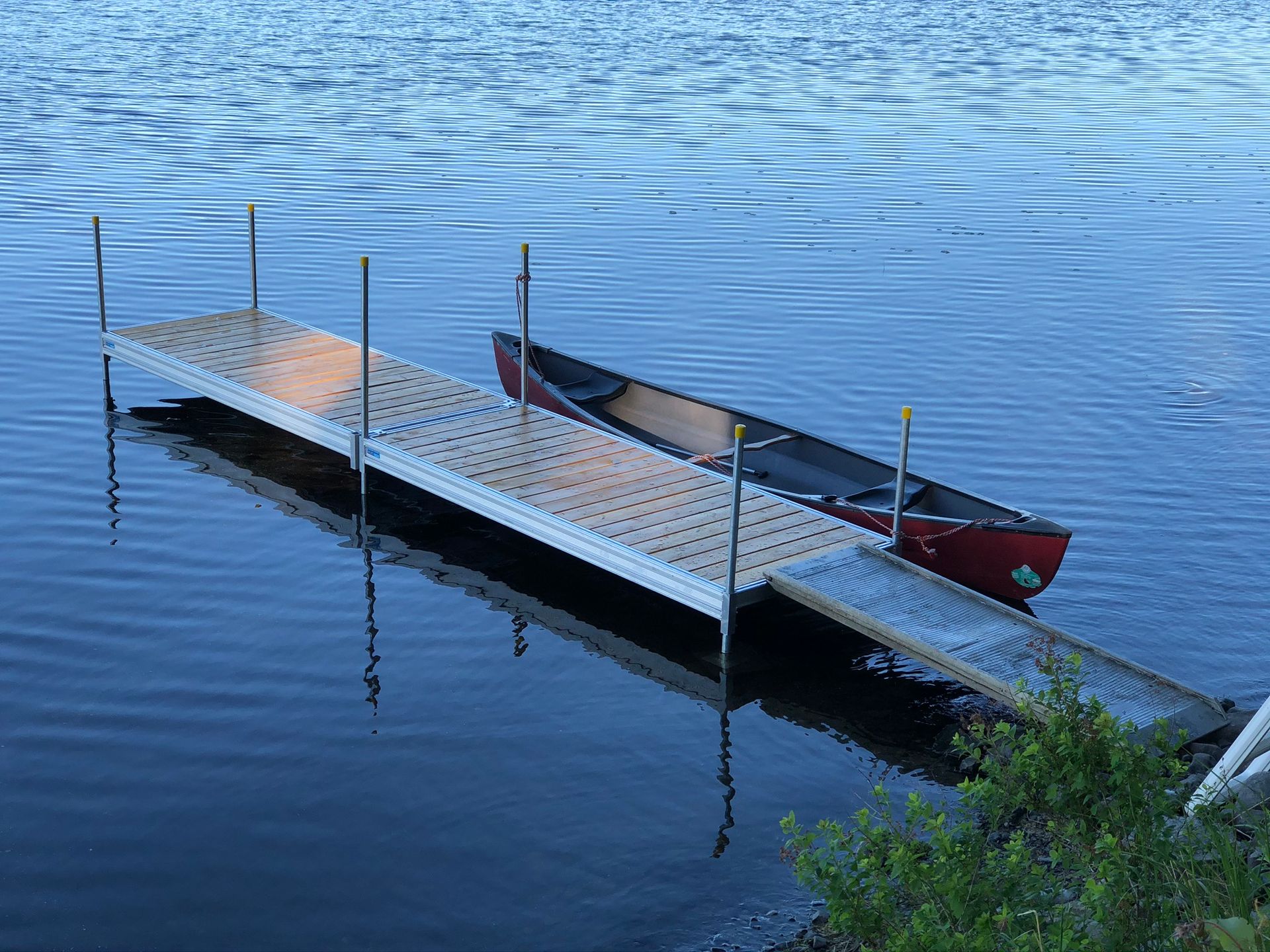 A canoe is docked at a dock on a lake.