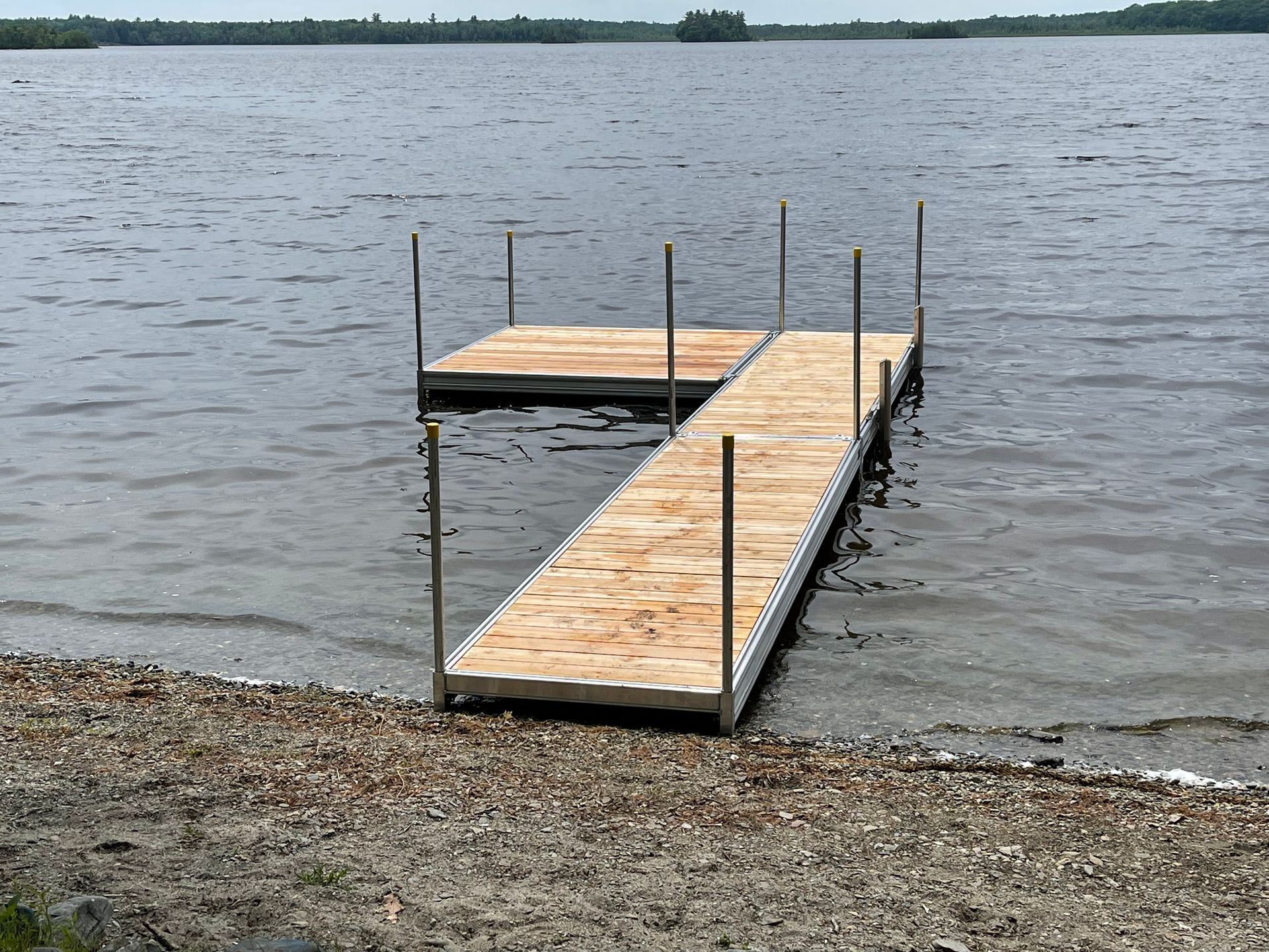 A wooden dock is sitting in the middle of a lake.