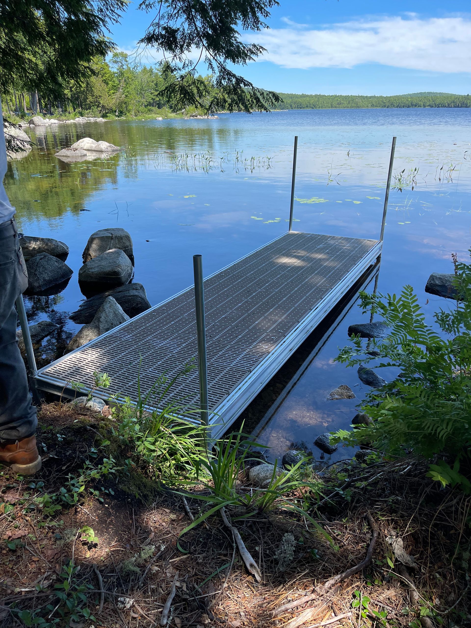 A dock is sitting on the shore of a lake.