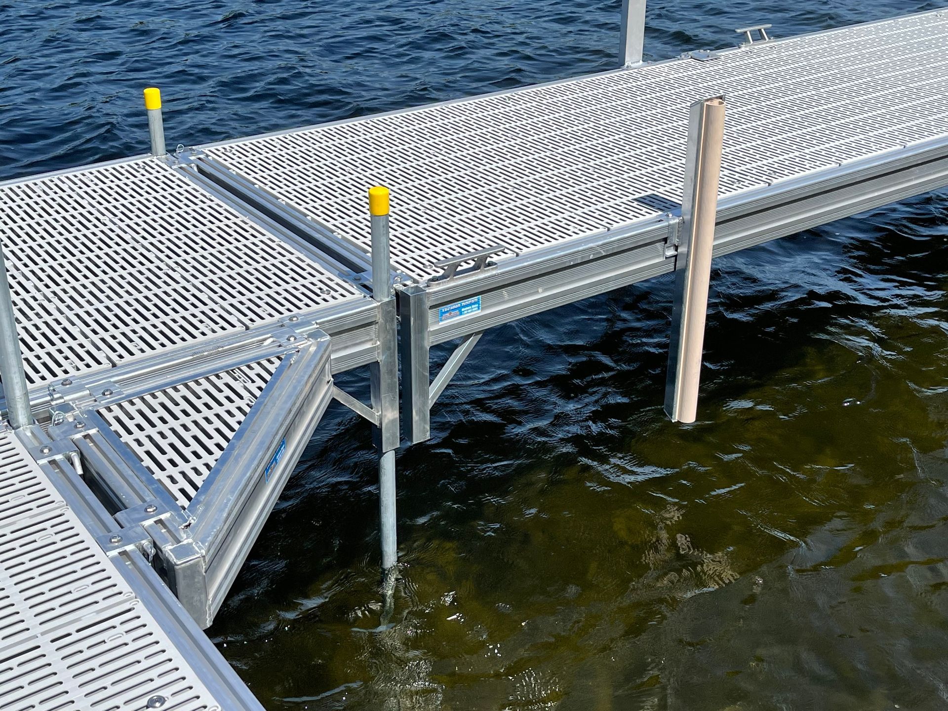 A metal dock with a wooden post in the water