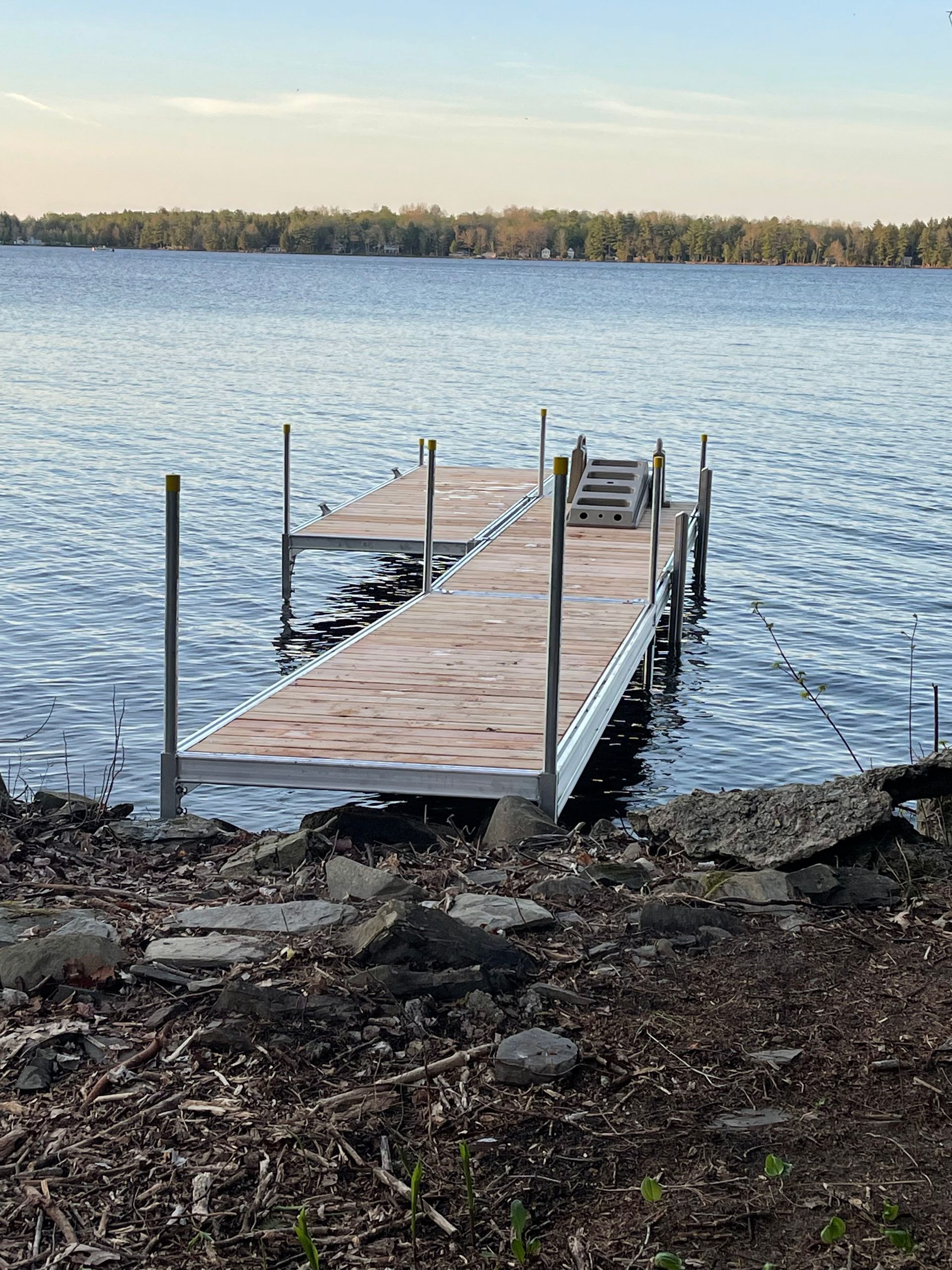 A wooden dock is sitting in the middle of a lake.