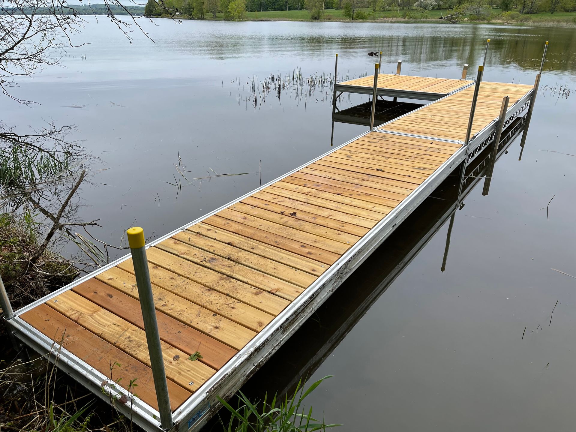 A wooden dock is sitting in the middle of a lake.