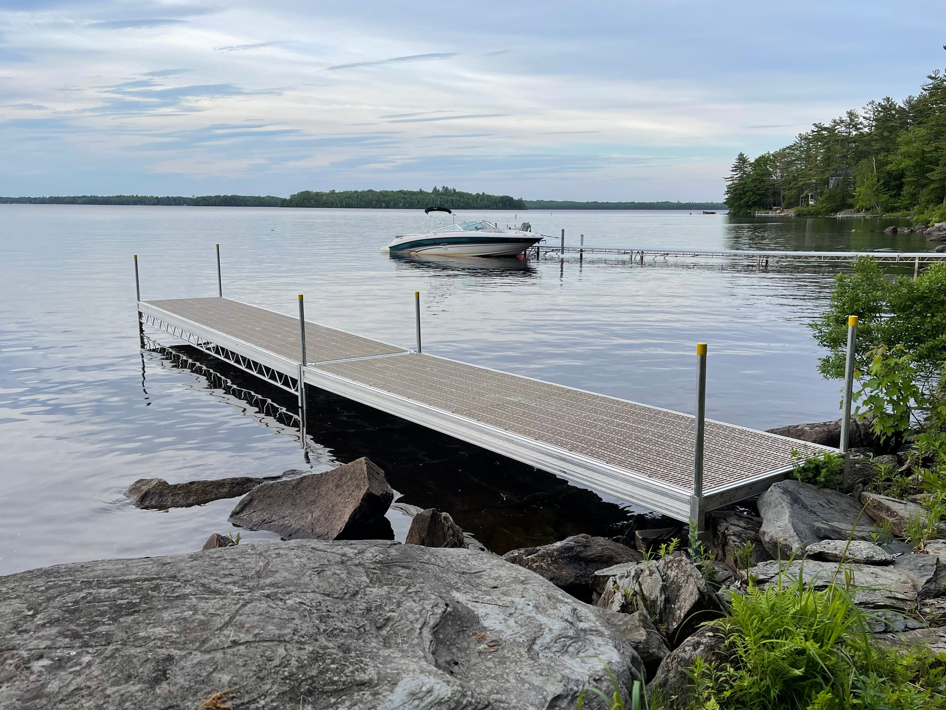 A dock on a lake with a boat in the water.