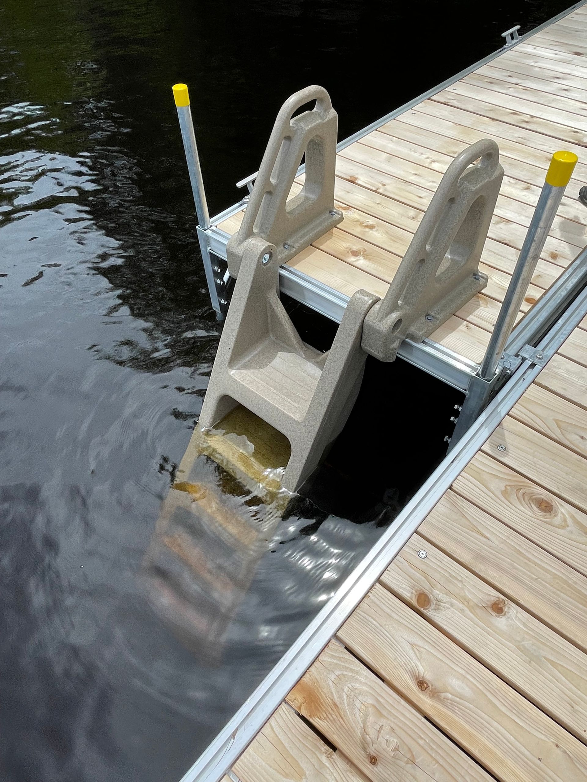 A wooden dock with a ladder going into the water.