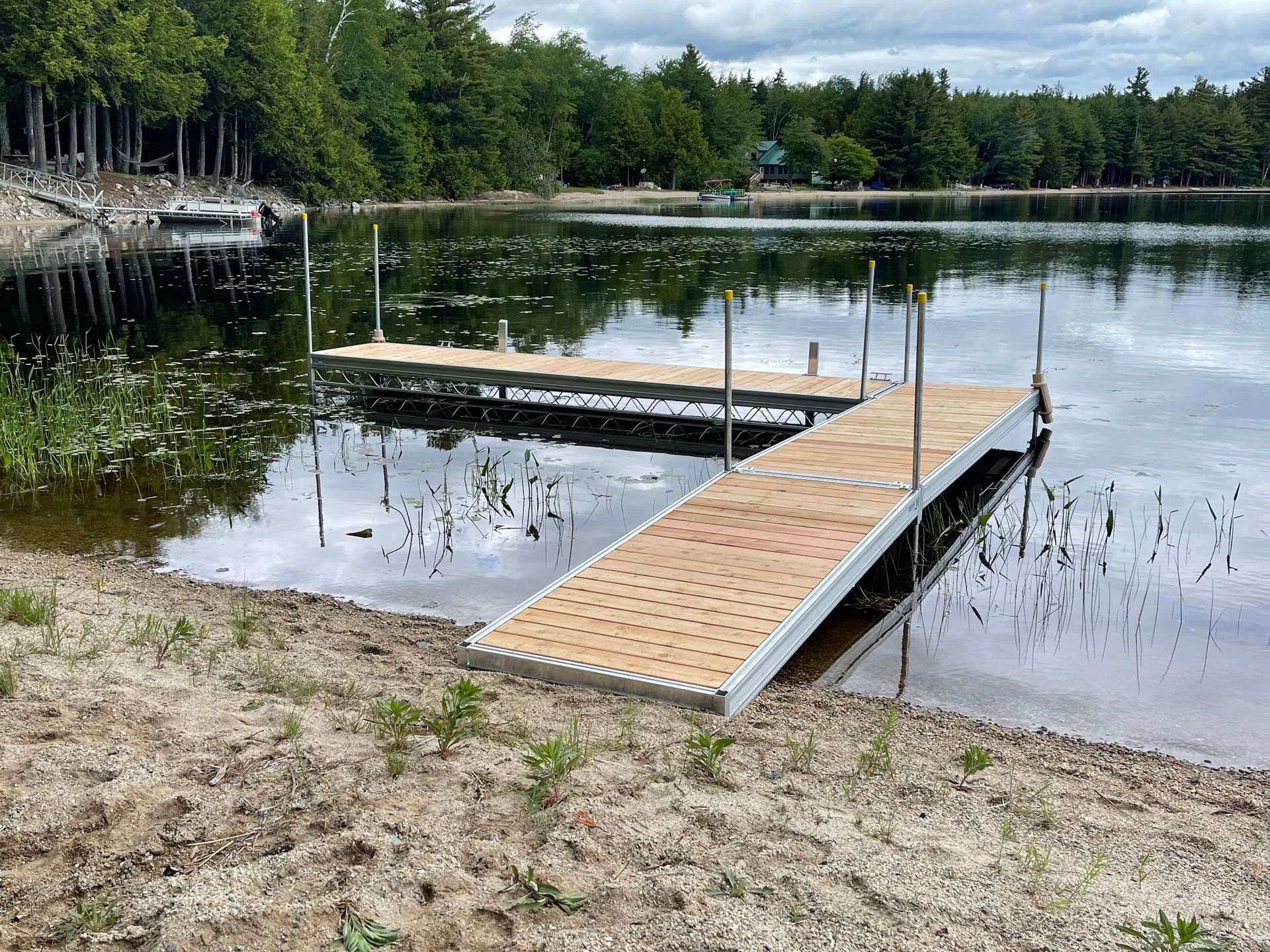 A wooden dock is sitting on the shore of a lake.