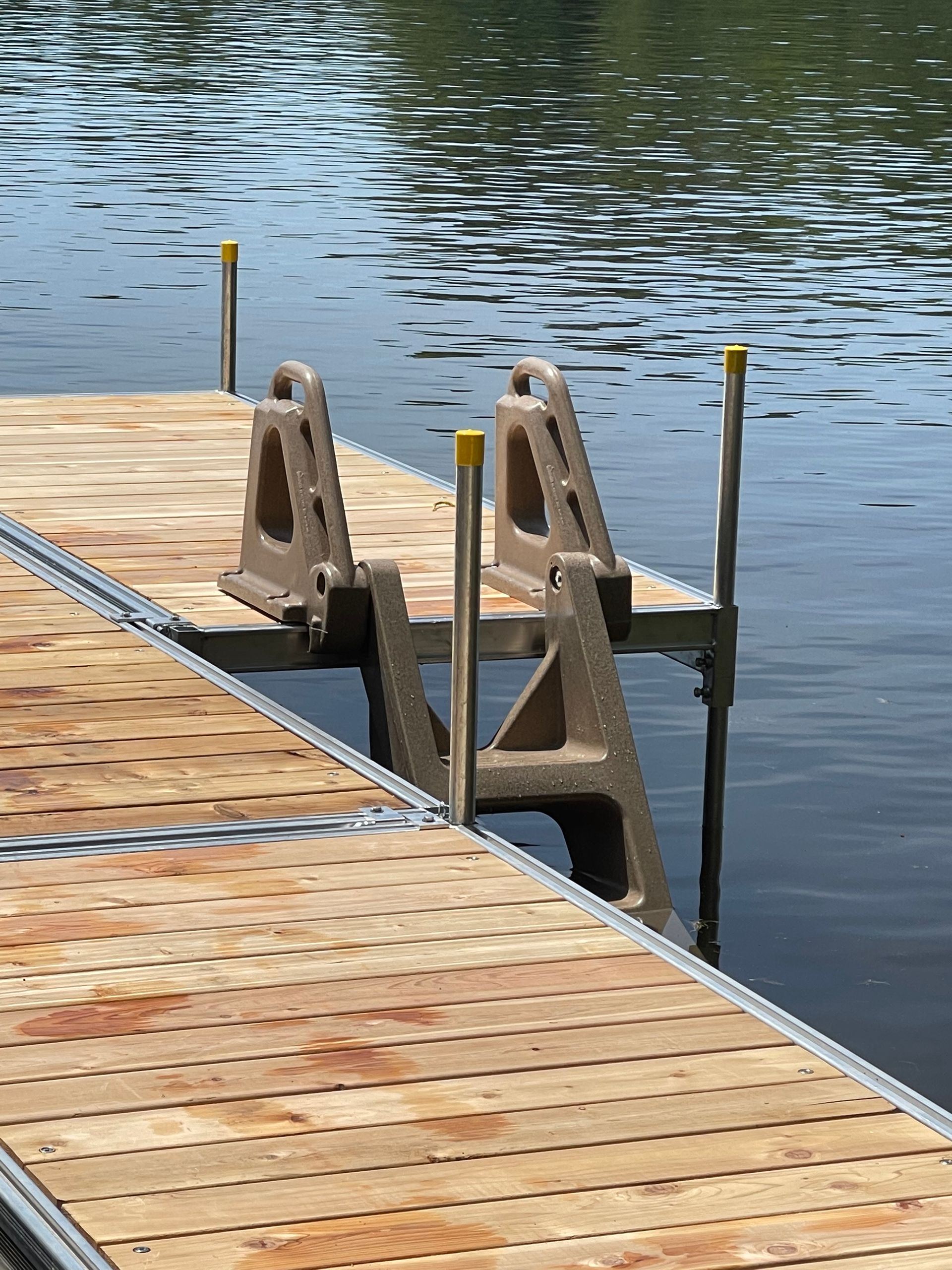 A wooden dock with a ladder attached to it is in the water.