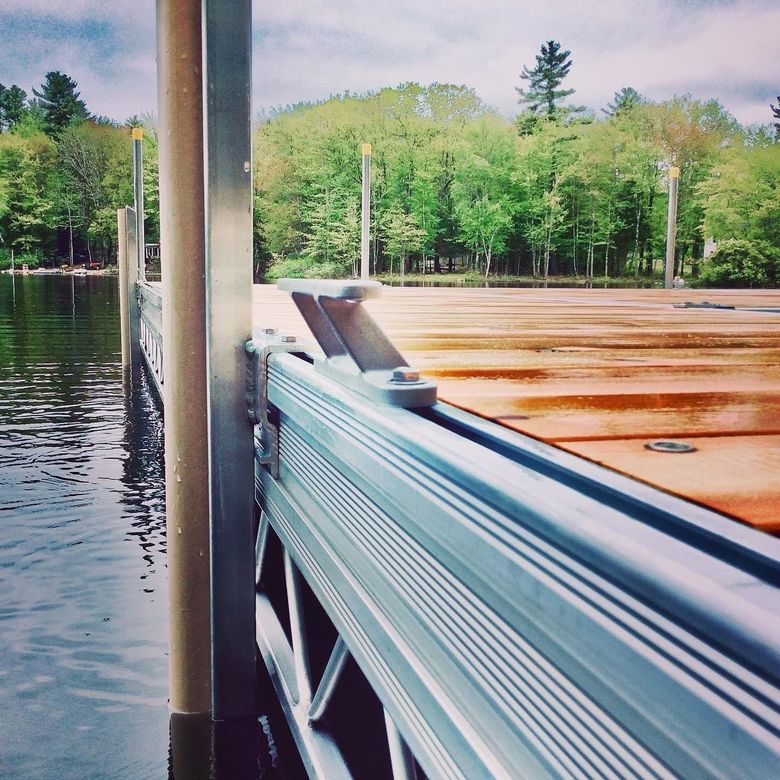 A dock on a lake with trees in the background