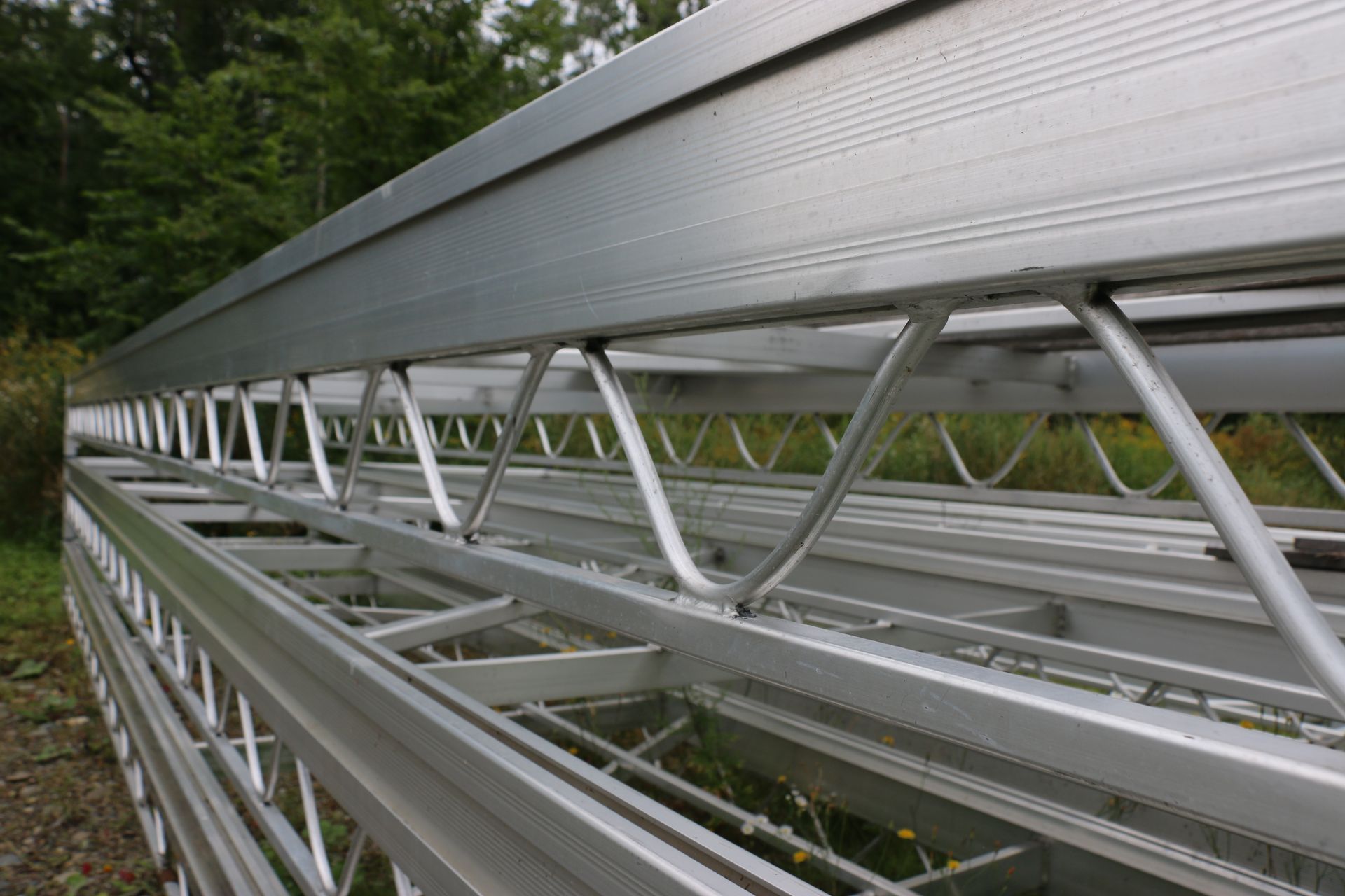 A close up of a metal structure with trees in the background.
