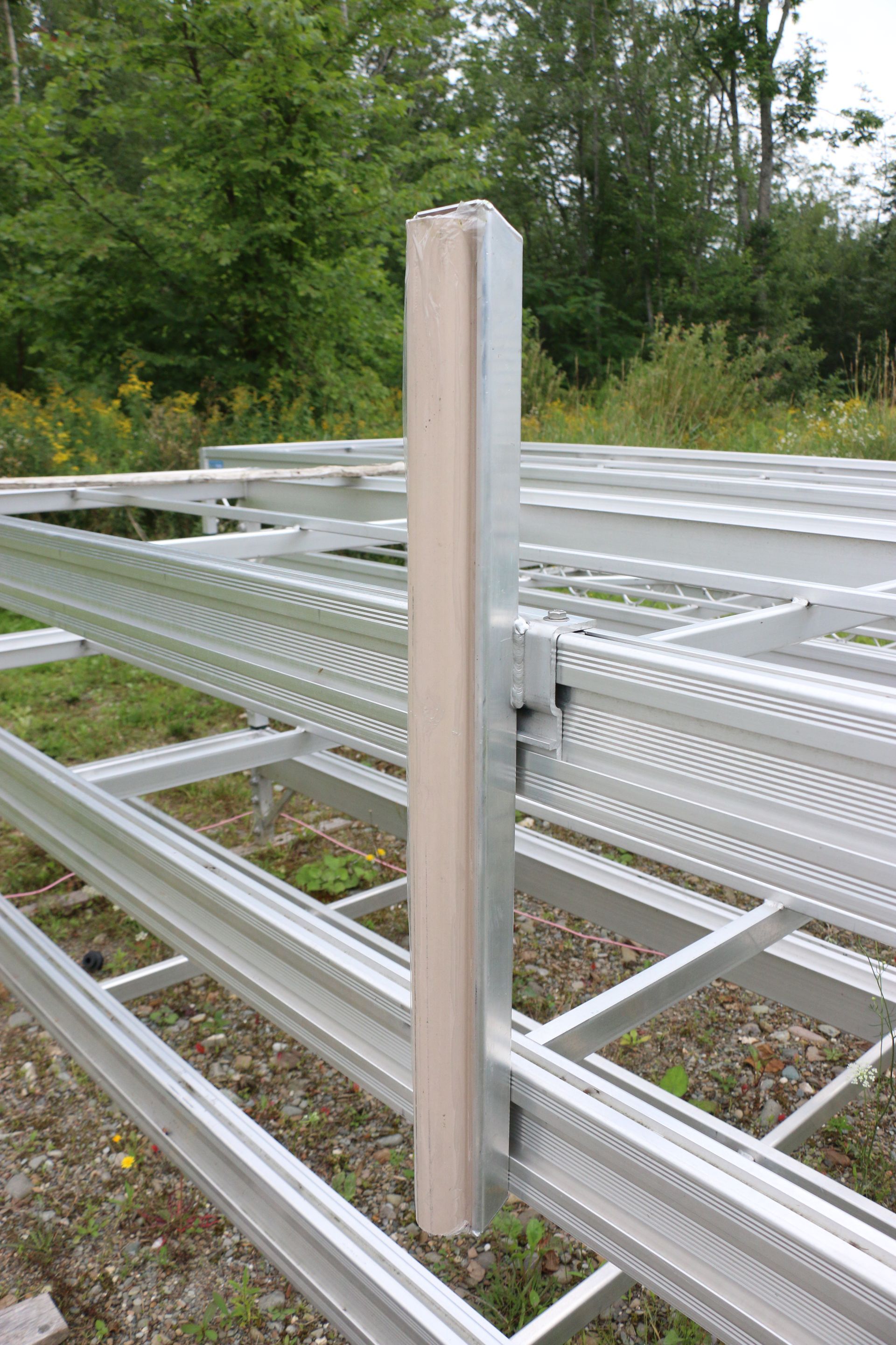 A metal fence with a wooden post in the middle of it.
