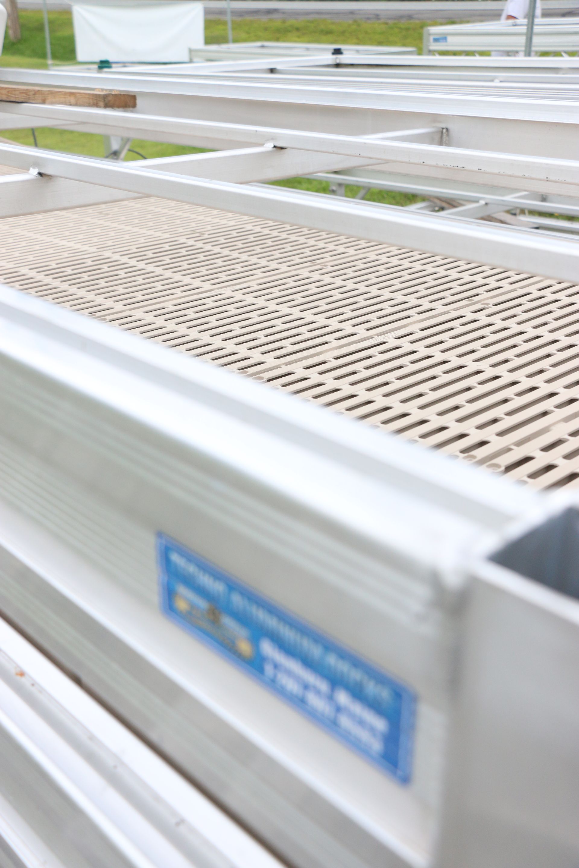A close up of a metal shelf with a blue sticker on it