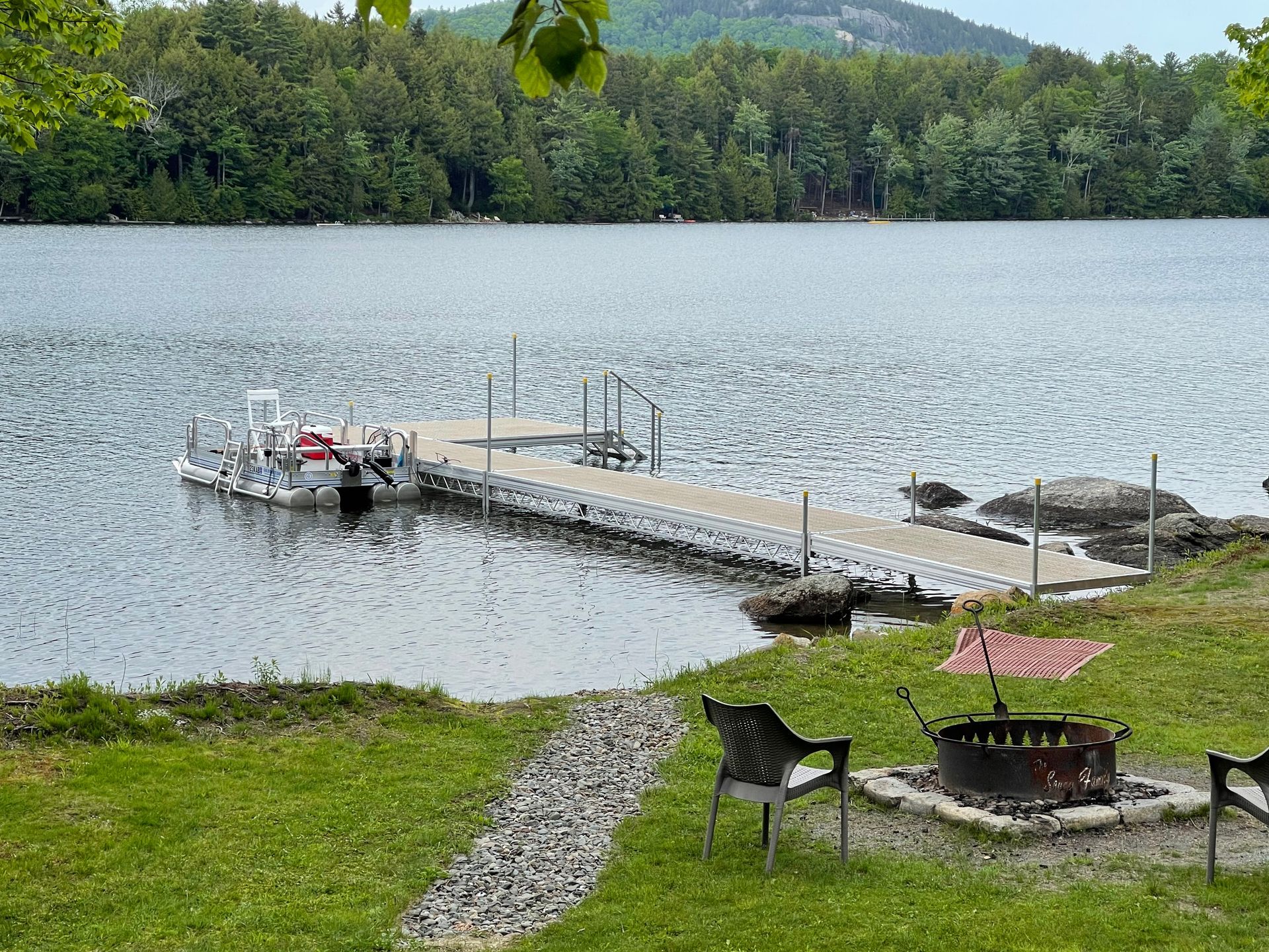 A boat is docked at a dock next to a lake.