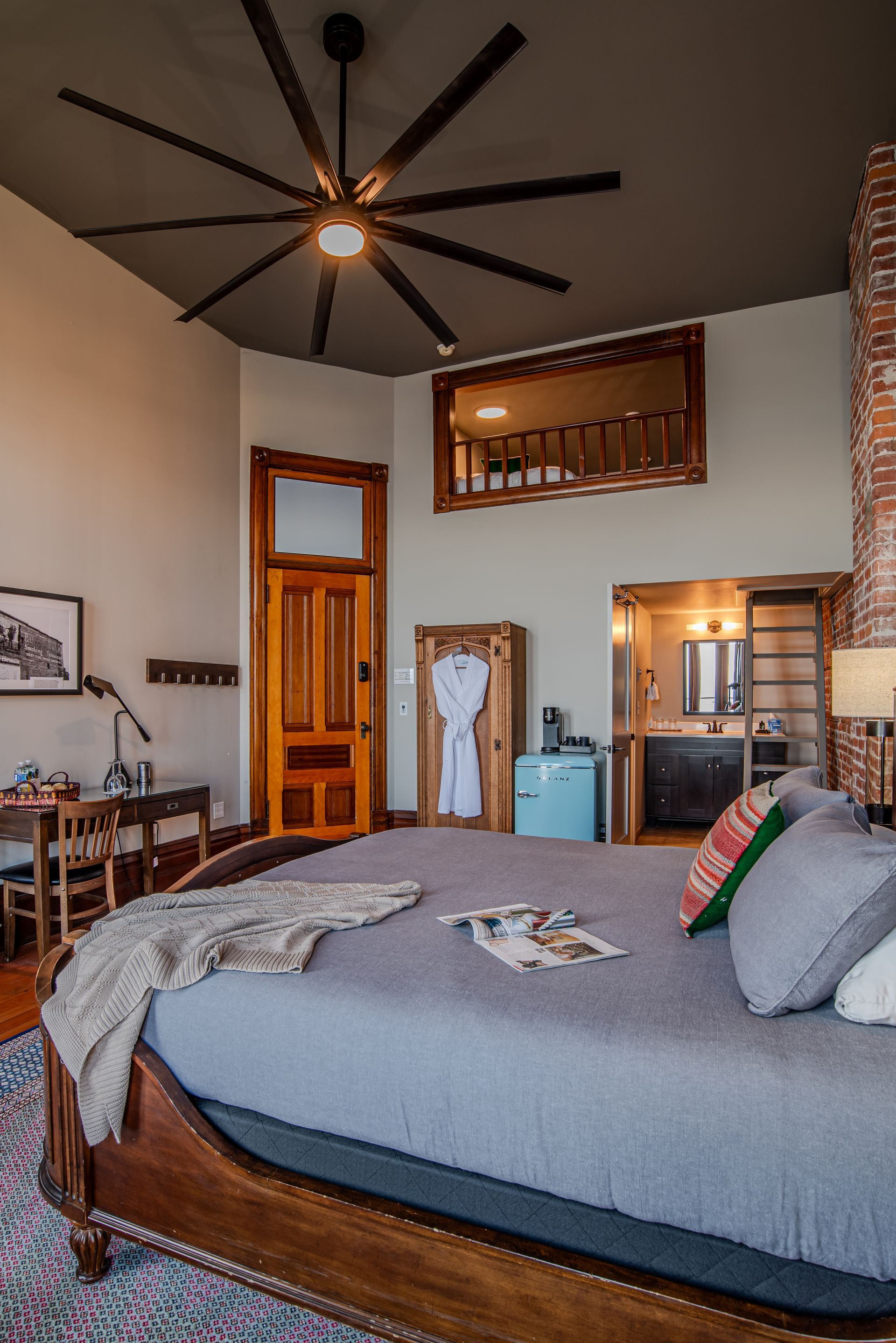 A bedroom with a large bed and a ceiling fan
