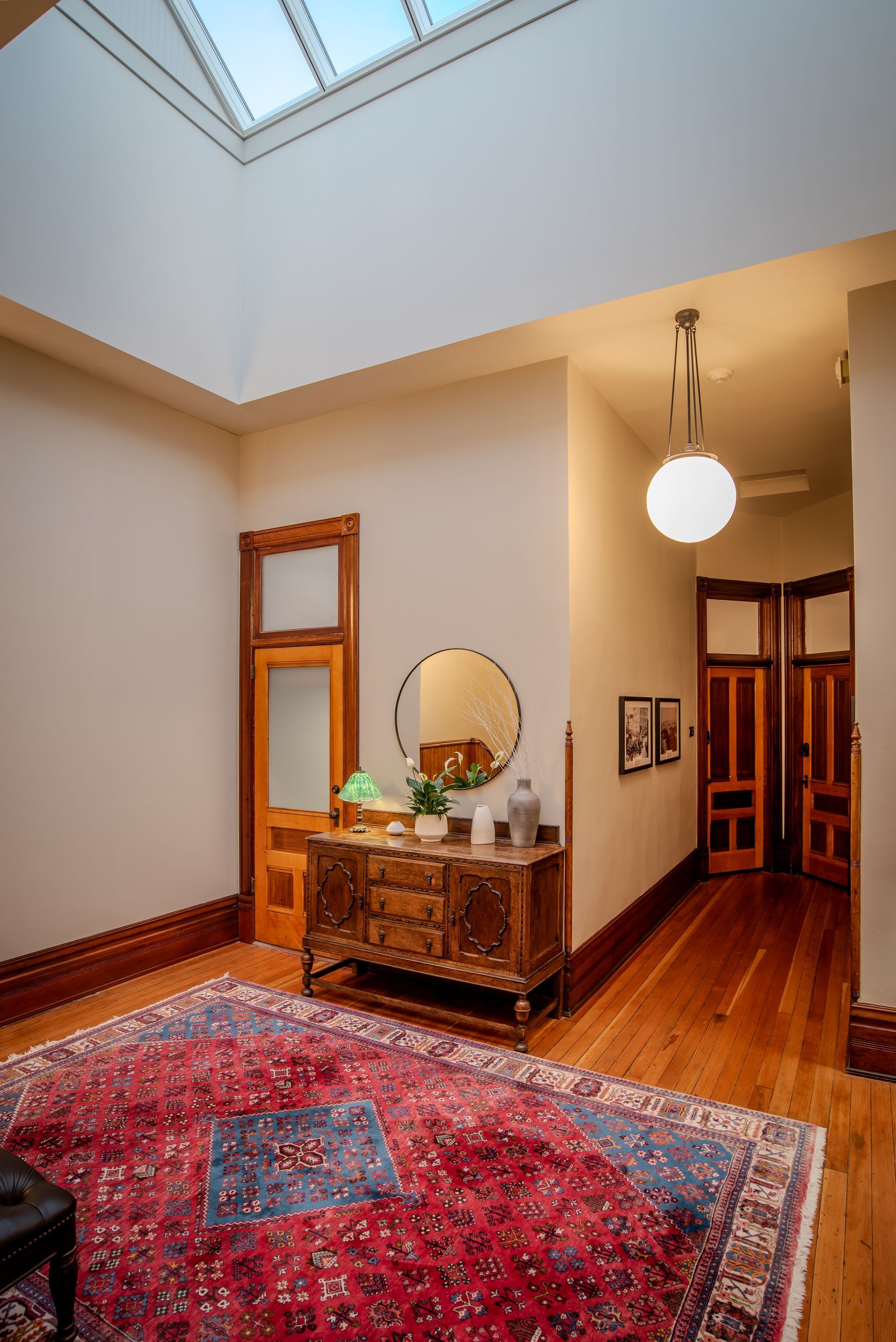 A hallway with a skylight and a rug on the floor