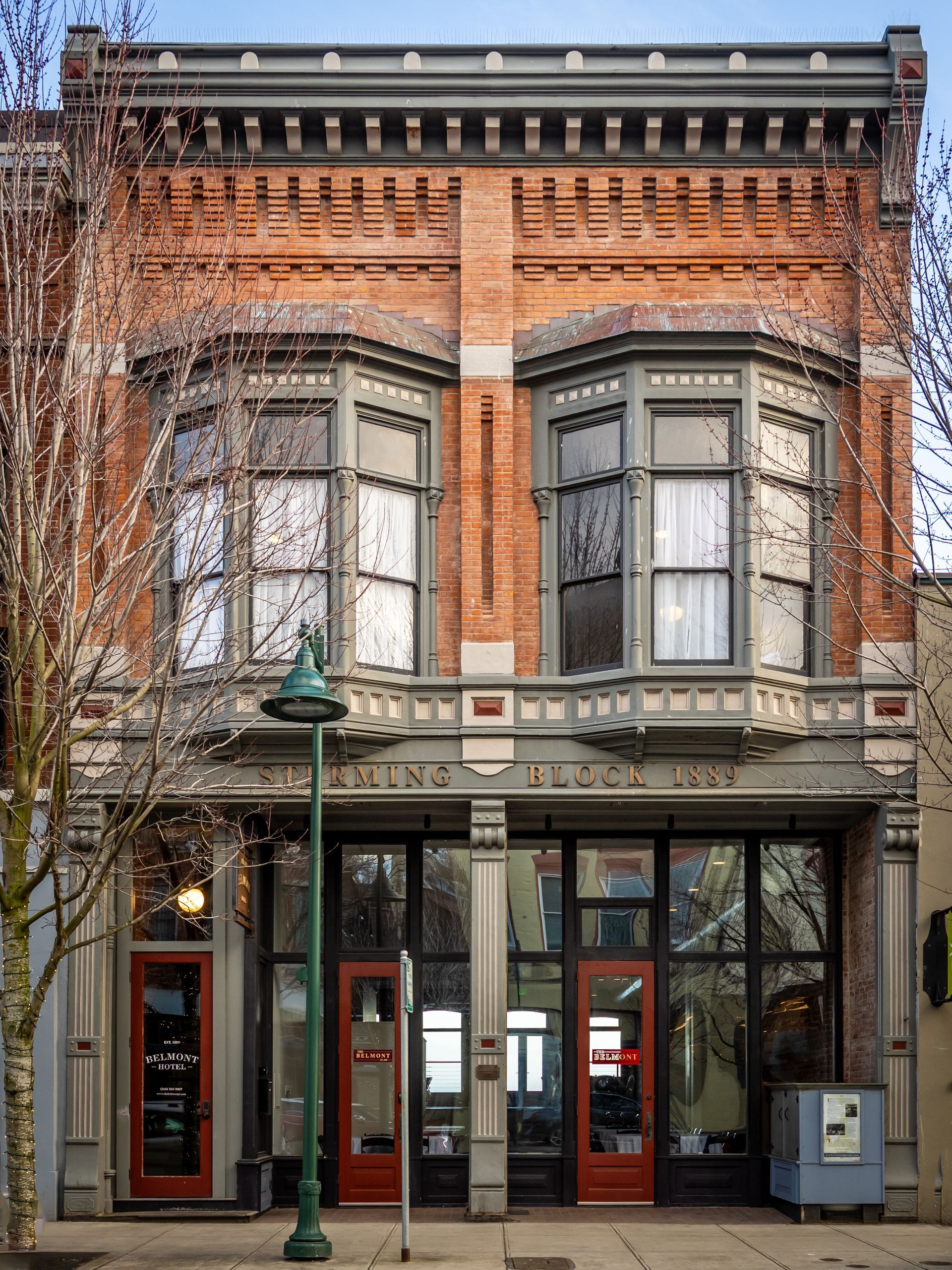 A large brick building with a green street light in front of it