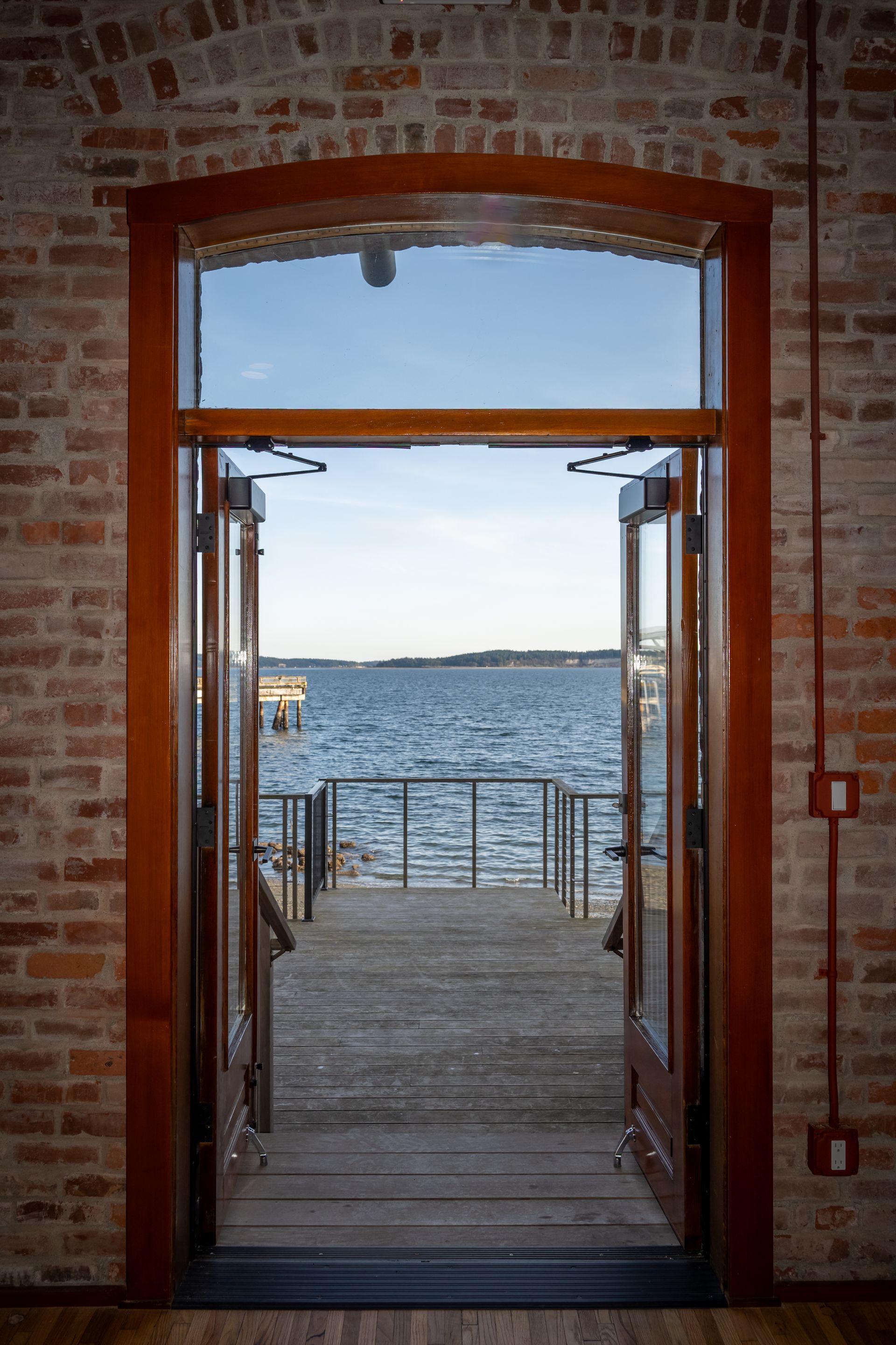 An open door leading to a dock overlooking a body of water