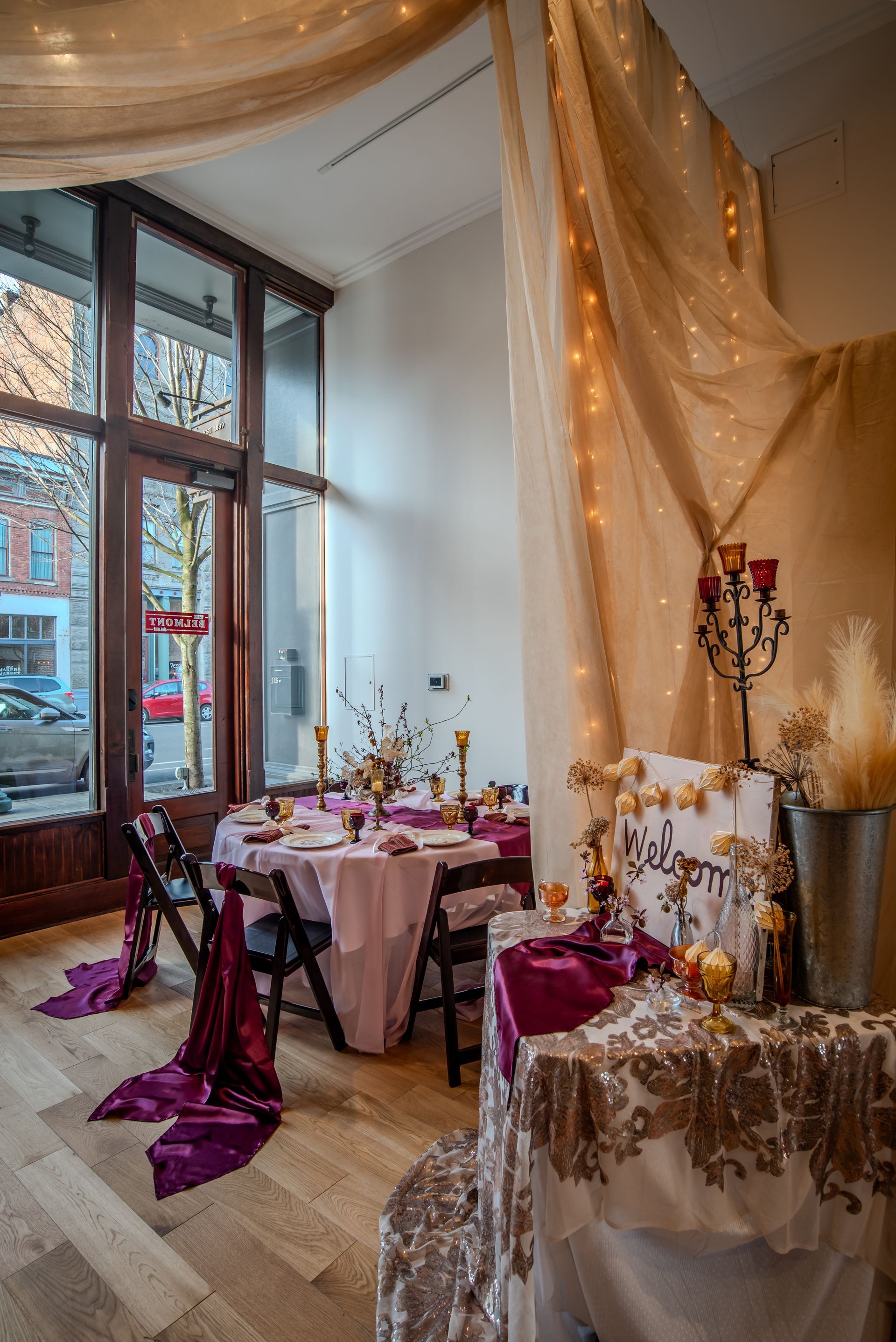 A room with tables and chairs set up for a wedding reception.