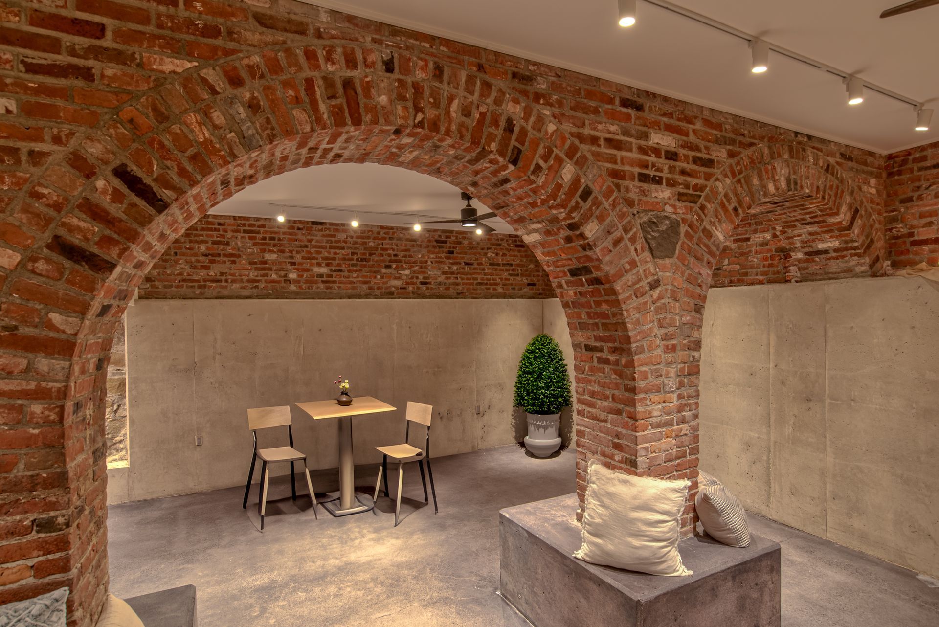 There is a table and chairs in the room with a brick wall.