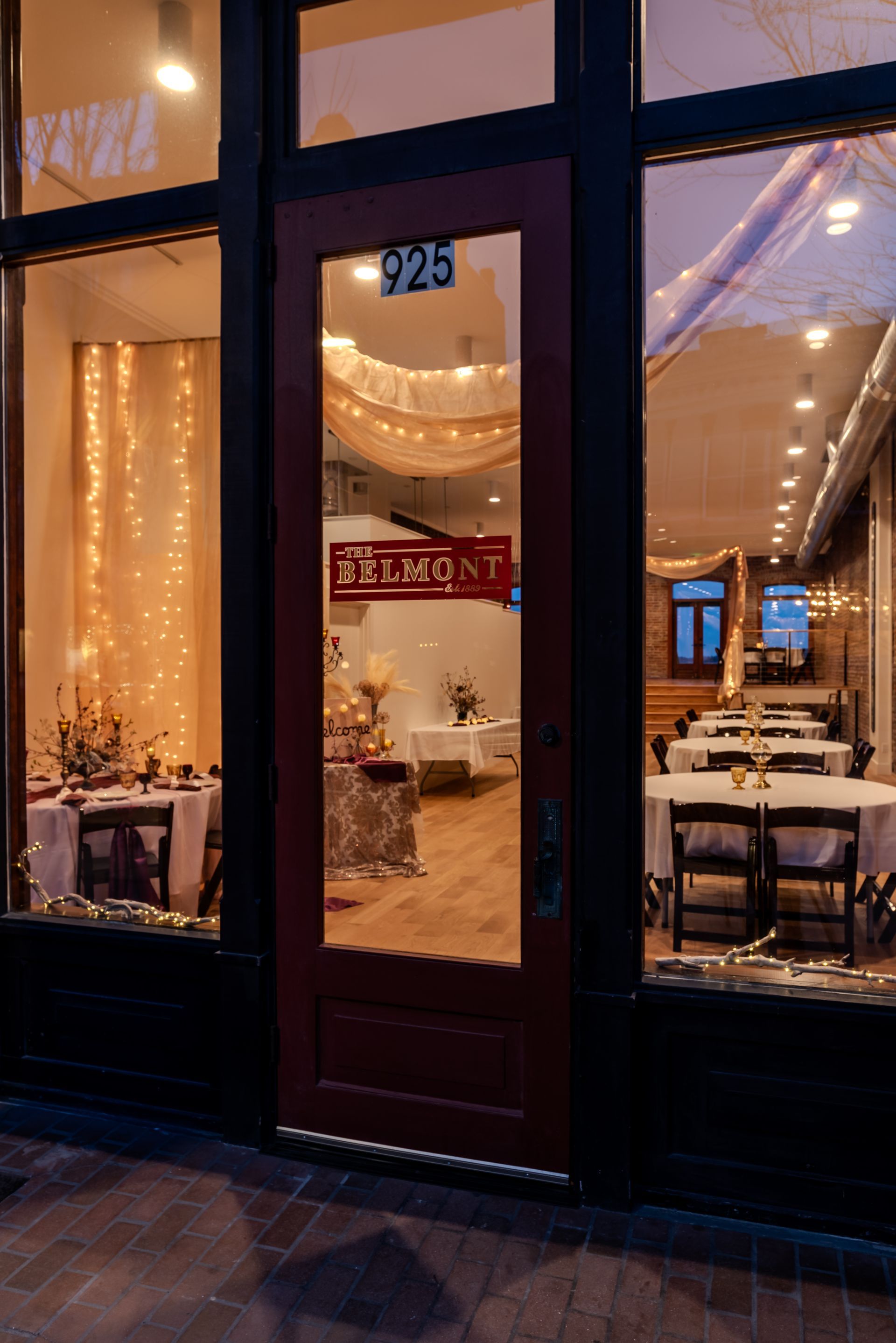 A restaurant with tables and chairs in front of a door.