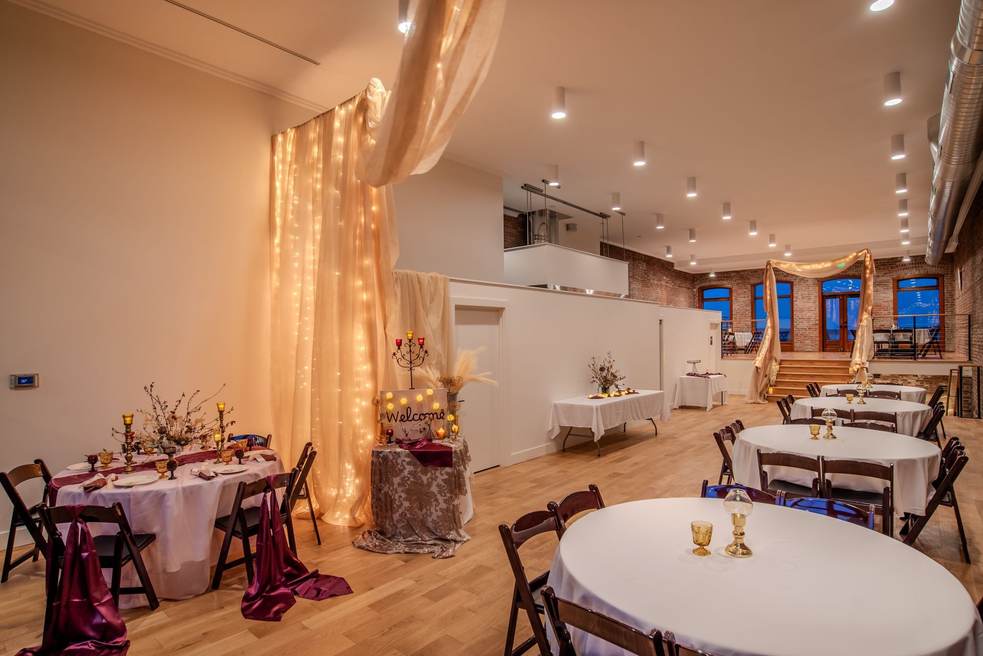 A large room with tables and chairs set up for a wedding reception.