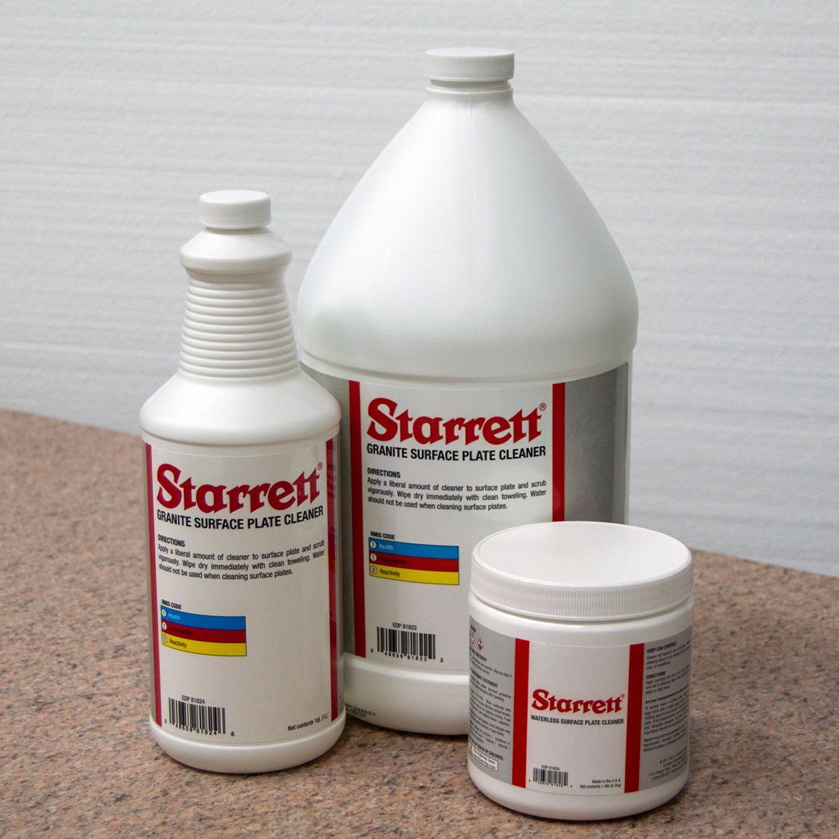 Assorted variety of cleaners in white bottles with Starrett logo