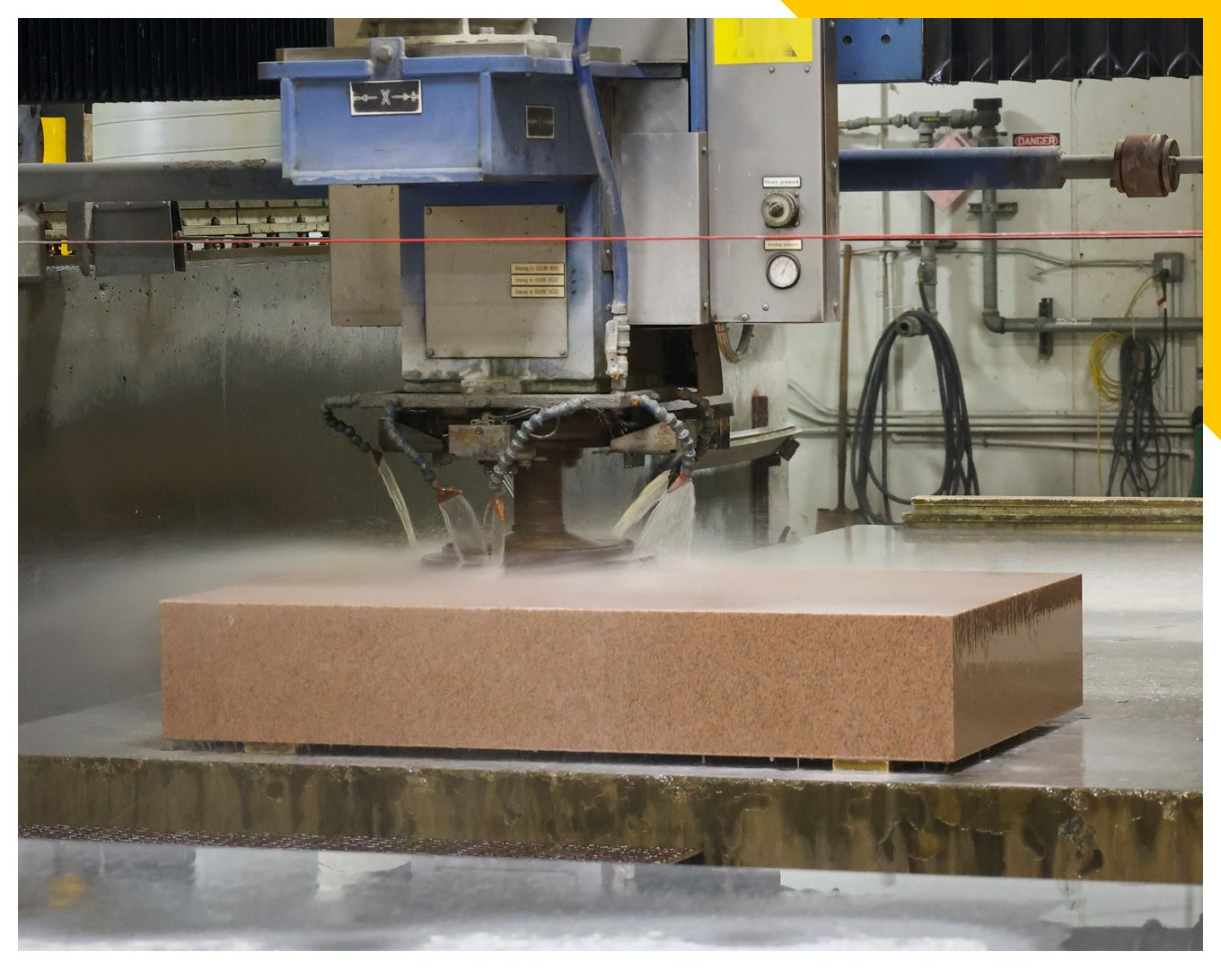 Machine cutting pink slab of granite
