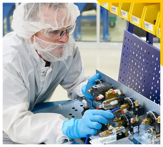 Mal worker with hair net inspecting part