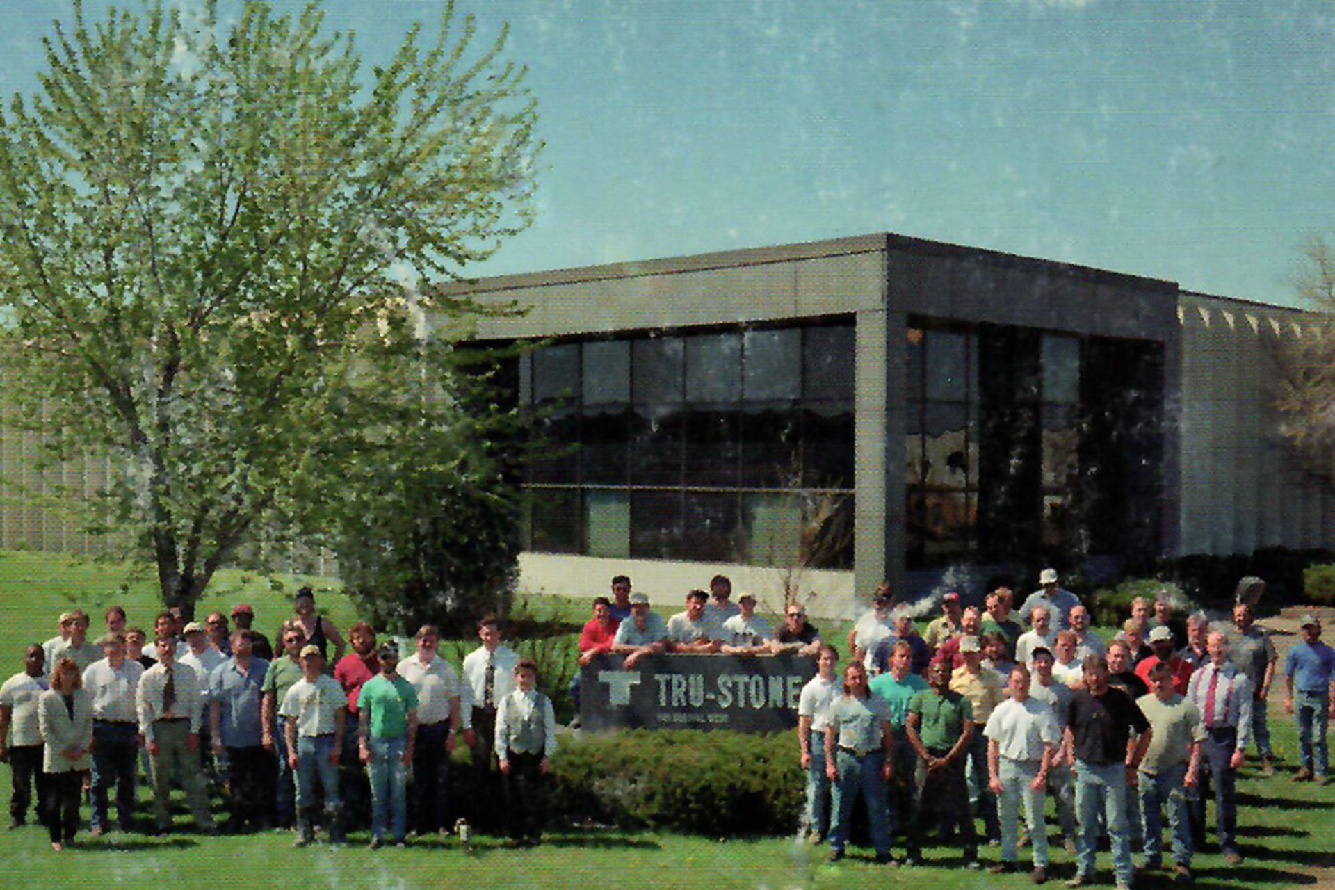 Older photo of workers in front of building
