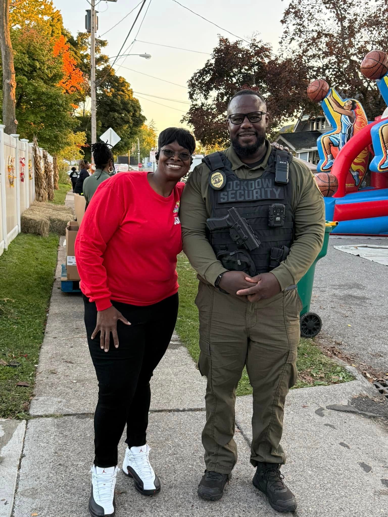 A man and a woman are standing next to each other on a sidewalk.