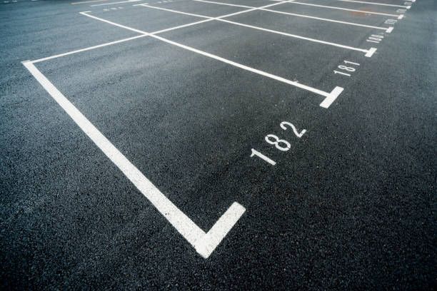 Empty asphalt parking spaces marked with white lines, numbered 181 and 182.