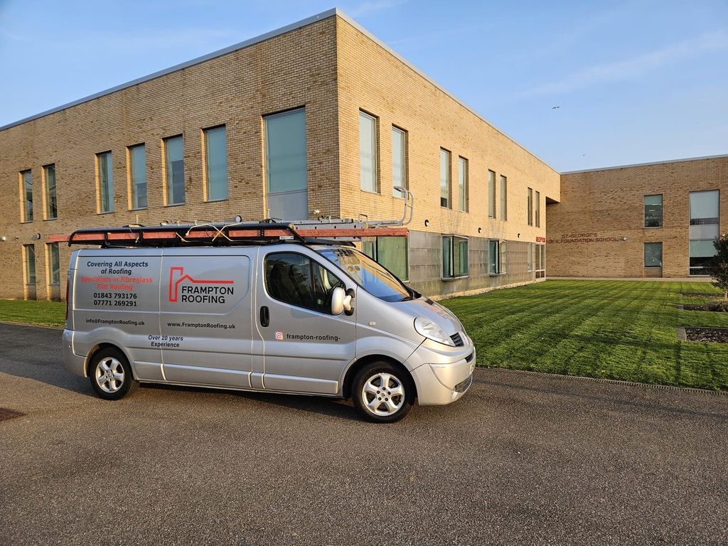 a silver van is parked in front of a large brick building .