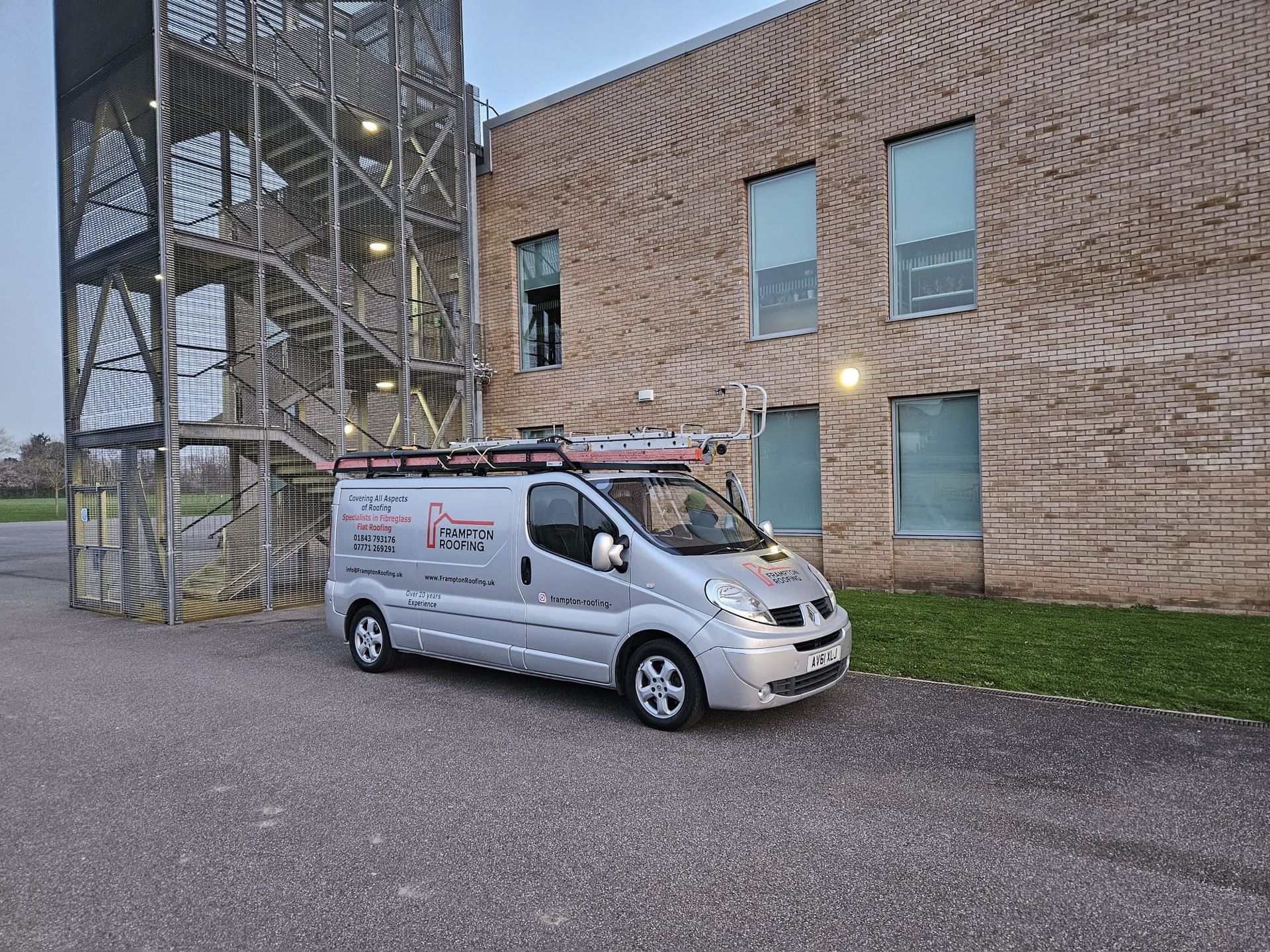 a silver Framton's Roofing van is parked in front of a brick building at St. Georges school.