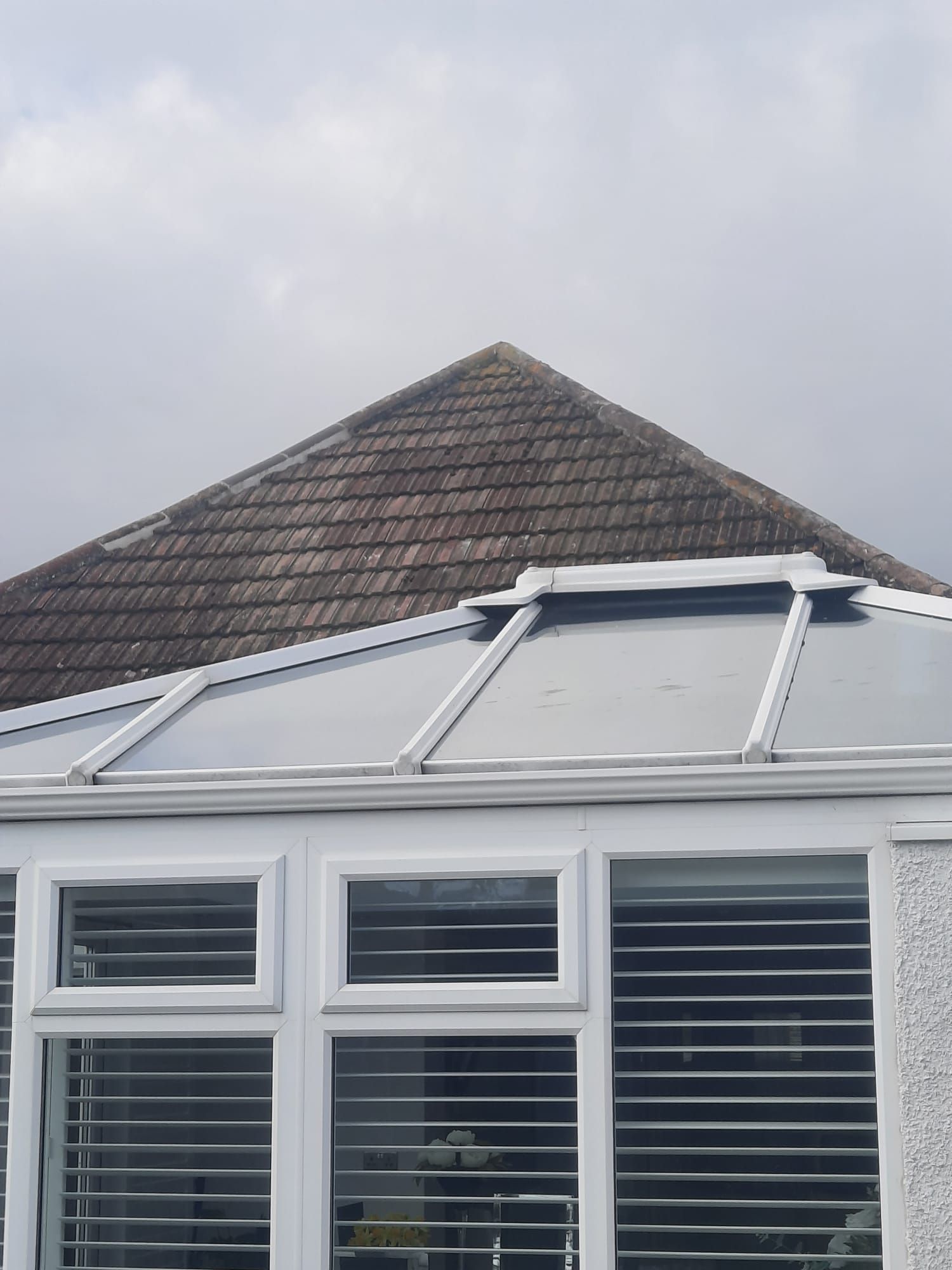a conservatory with a roof that is covered in shingles .