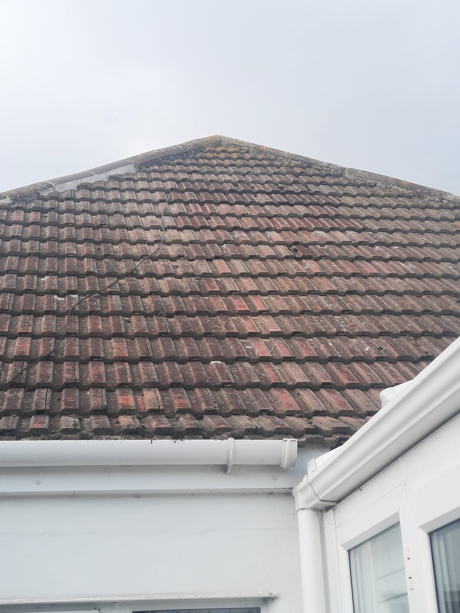 the roof of a house with a tiled roof and gutters .