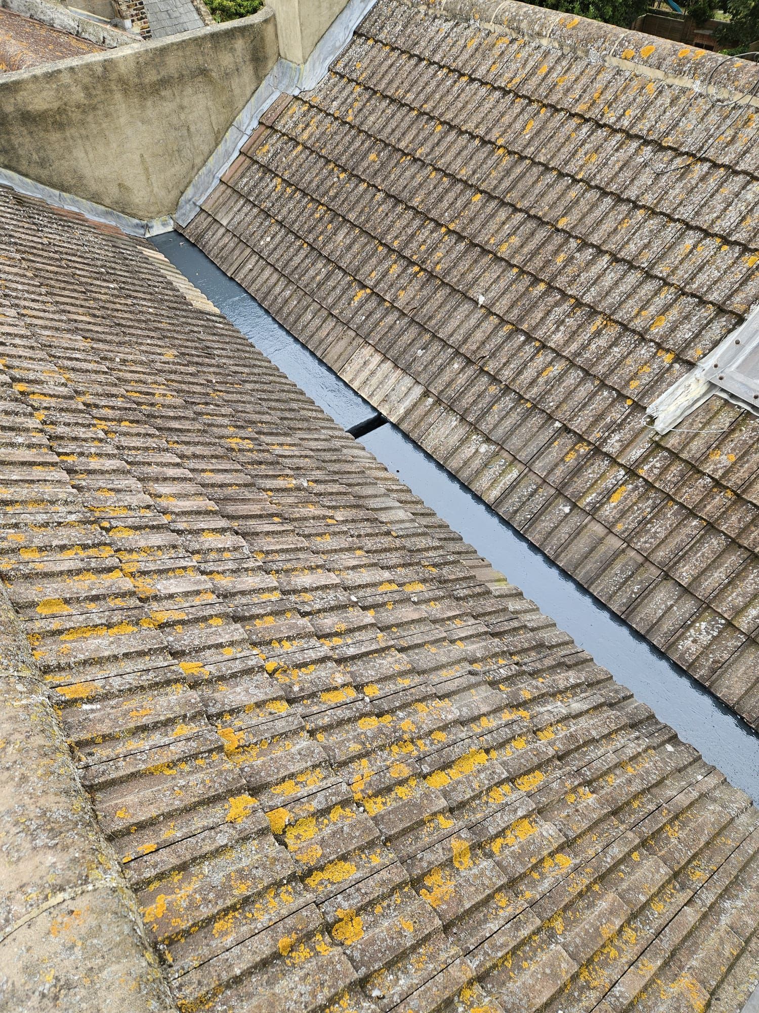 A close up of a roof with a drain on it.