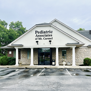 Exterior of Pediatric Associates of Mt. Carmel building with columns, stone facade, and overcast sky.