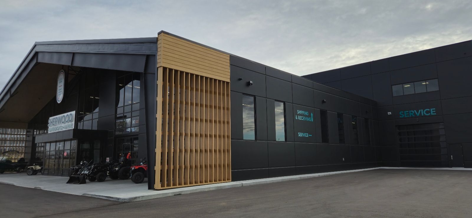 Modern black building with wood accents and large windows, likely a business or commercial space.