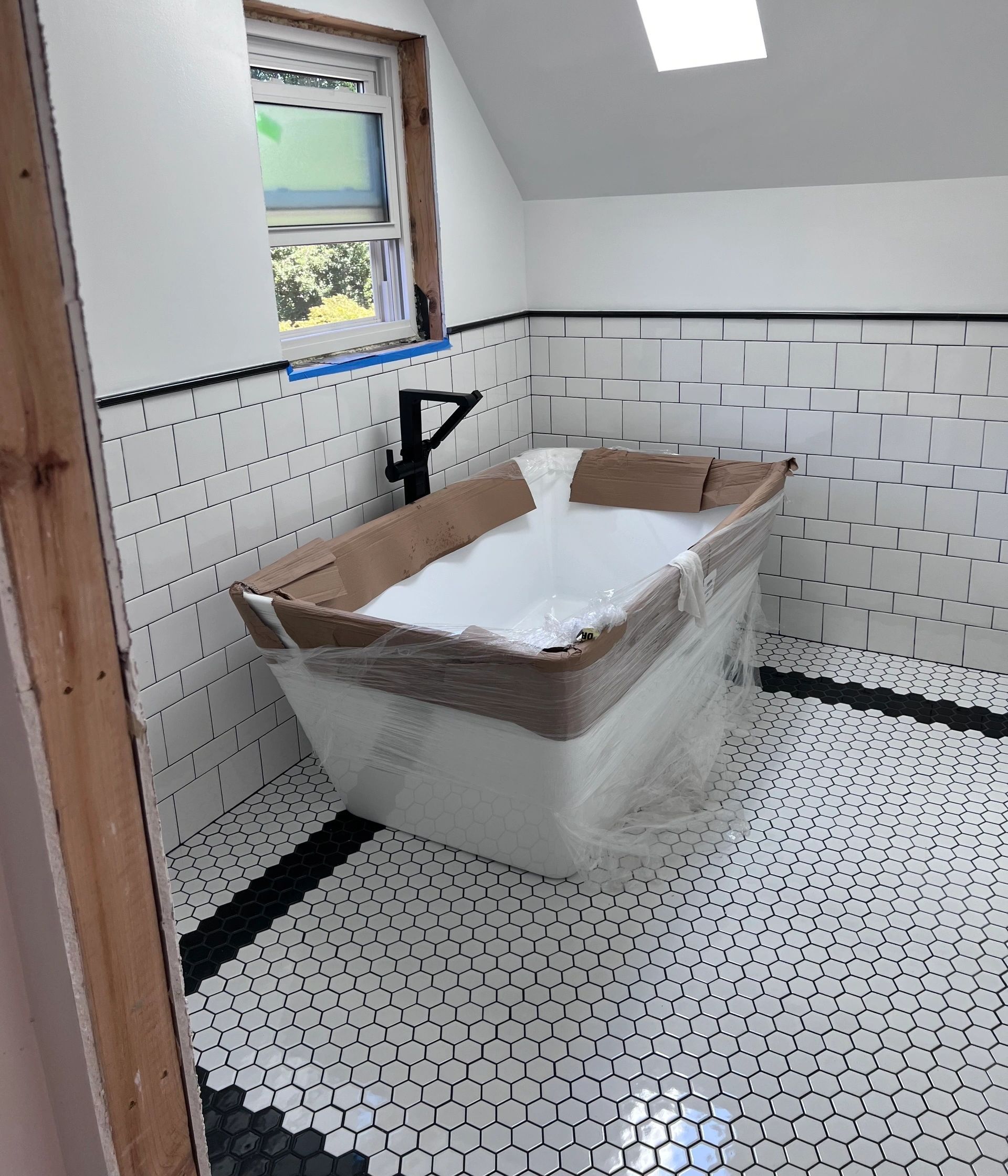 A bathtub is sitting in a bathroom under construction.